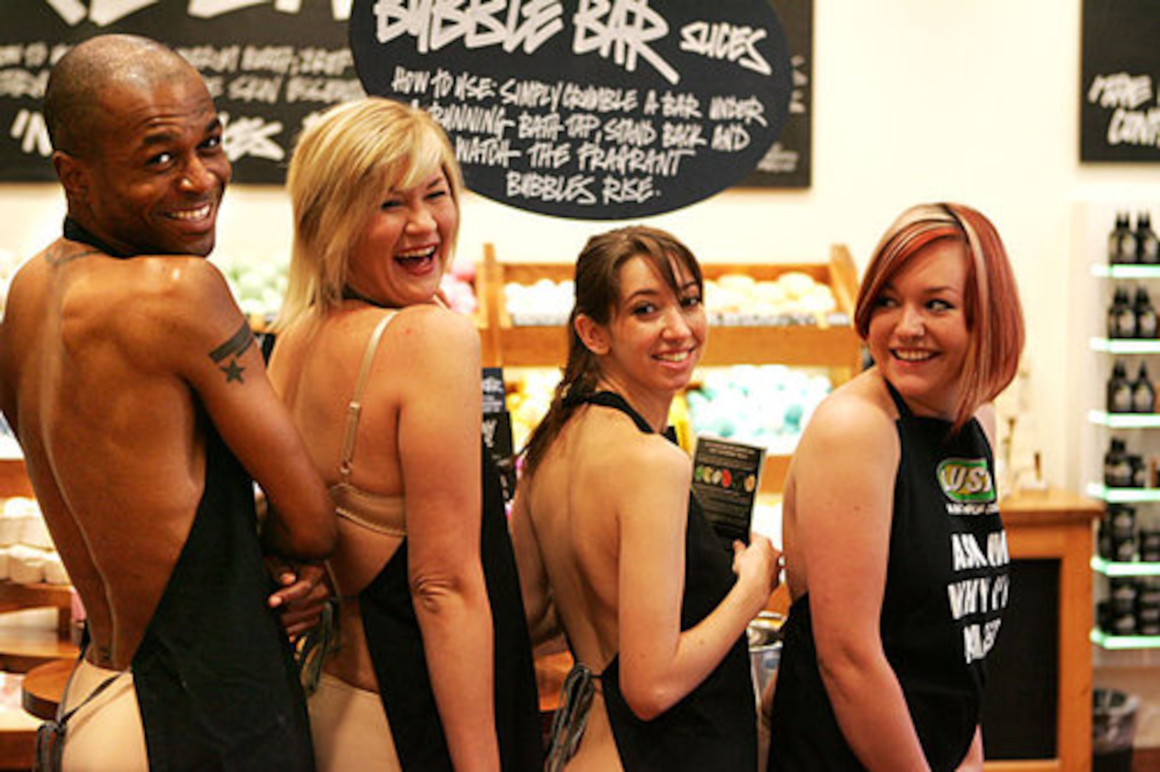 The shopkeepers at Lush in Lenox Mall were nearly naked (they wore underpants) behind their aprons on Wednesday to protest unnecessary packaging. Left to right are Daron Fowler, 28, Atlanta; Bethany Ellis, 27, Atlanta; Nichole Evans, 22, Atlanta; and Stephanie Nadeau, 19, McDonough.