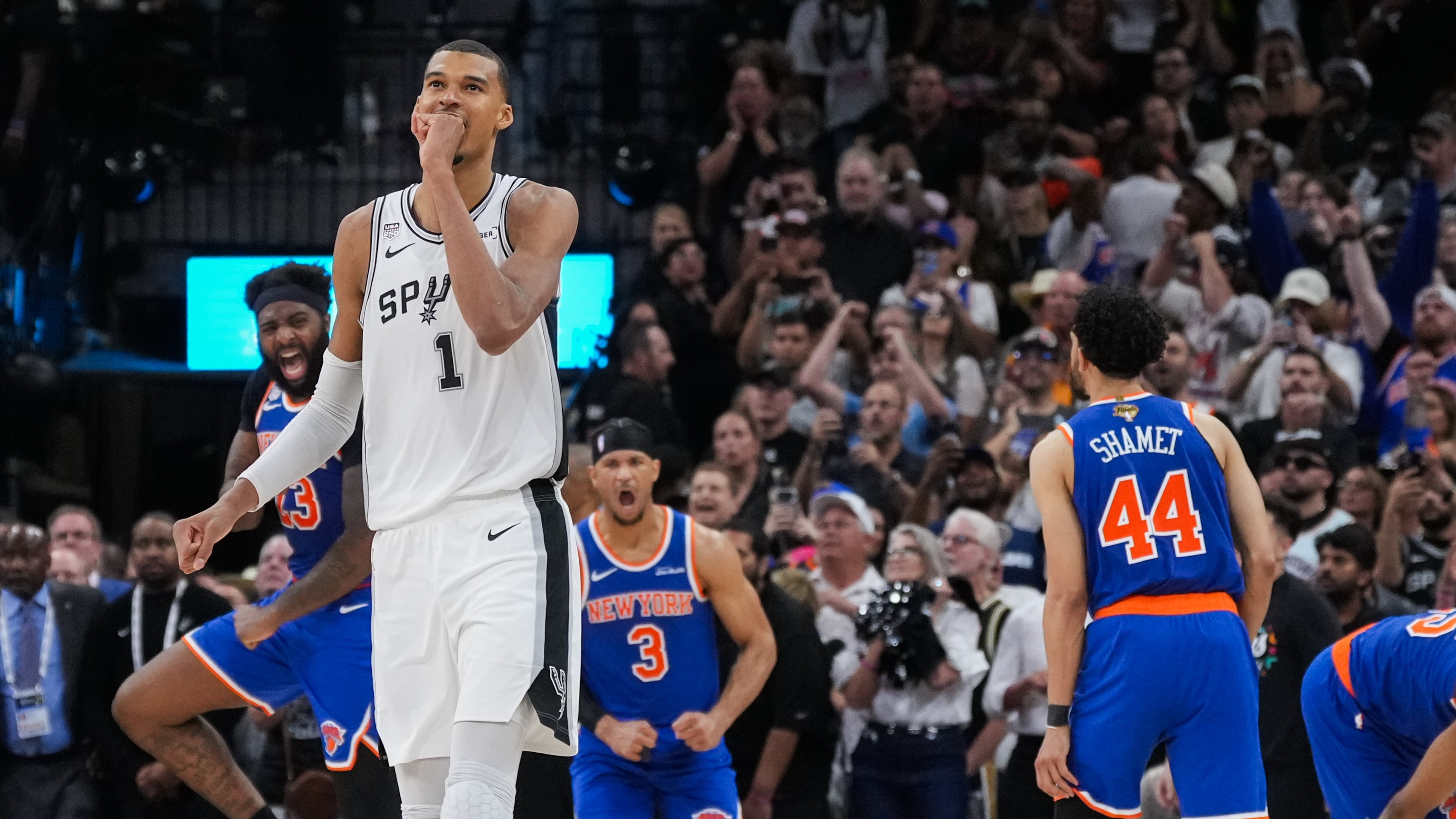 San Antonio Spurs forward Victor Wembanyama walks off the court as time expires during the second half of Game 2 of the NBA Finals basketball series as New York Knicks guard Landry Shamet (44), guard Josh Hart (3), and center Mitchell Robinson (23) celebrate, Friday, June 5, 2026, in San Antonio. (AP Photo/Eric Gay)
