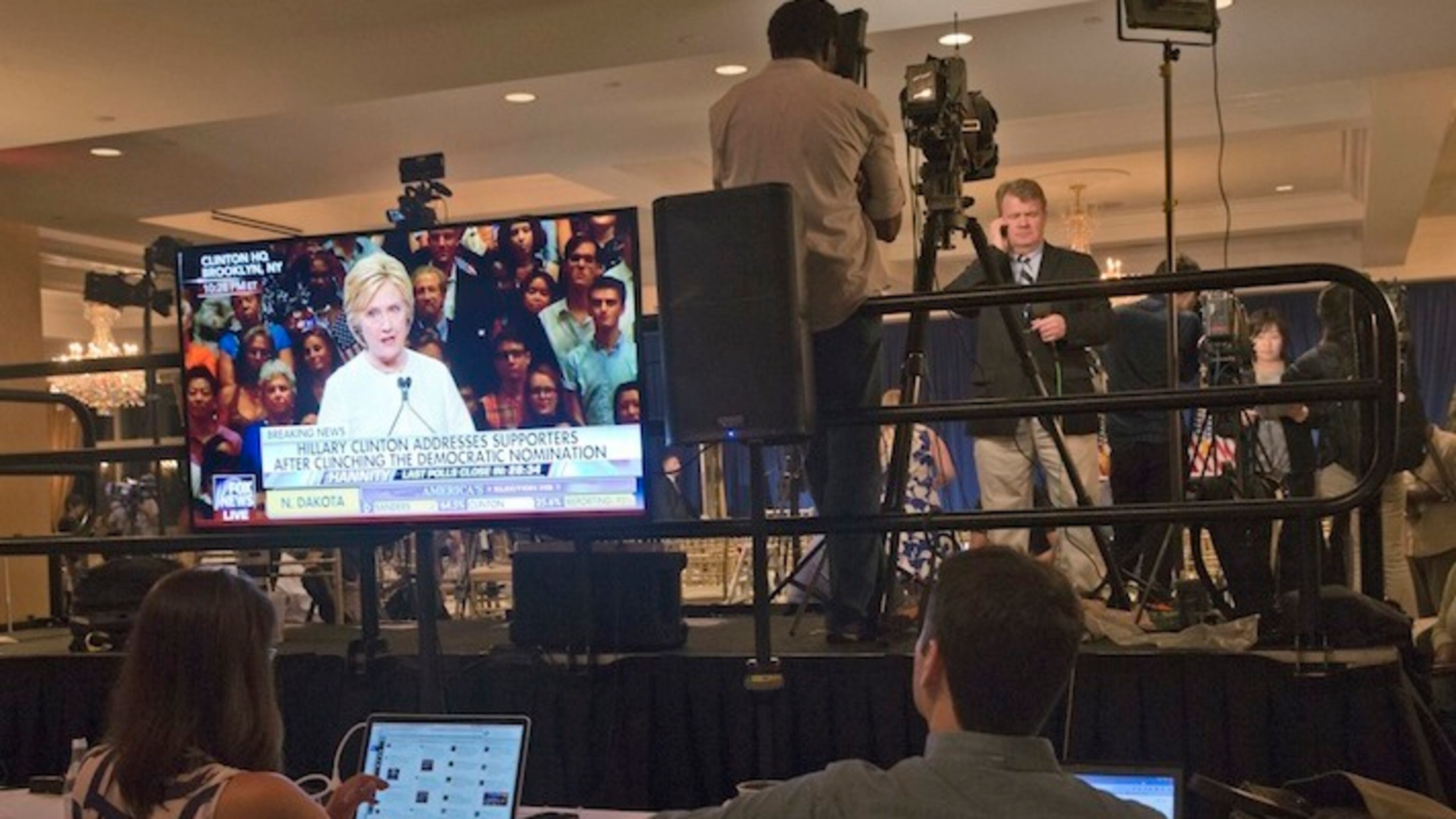 Democratic presidential candidate Hillary Clinton is seen on a television screen addressing her supporters as reporters file their stories after a news conference by Republican presidential candidate Donald Trump at the Trump National Golf Club Westchester, Tuesday, June 7, 2016, in Briarcliff Manor, N.Y. ( Photo/Mary Altaffer)