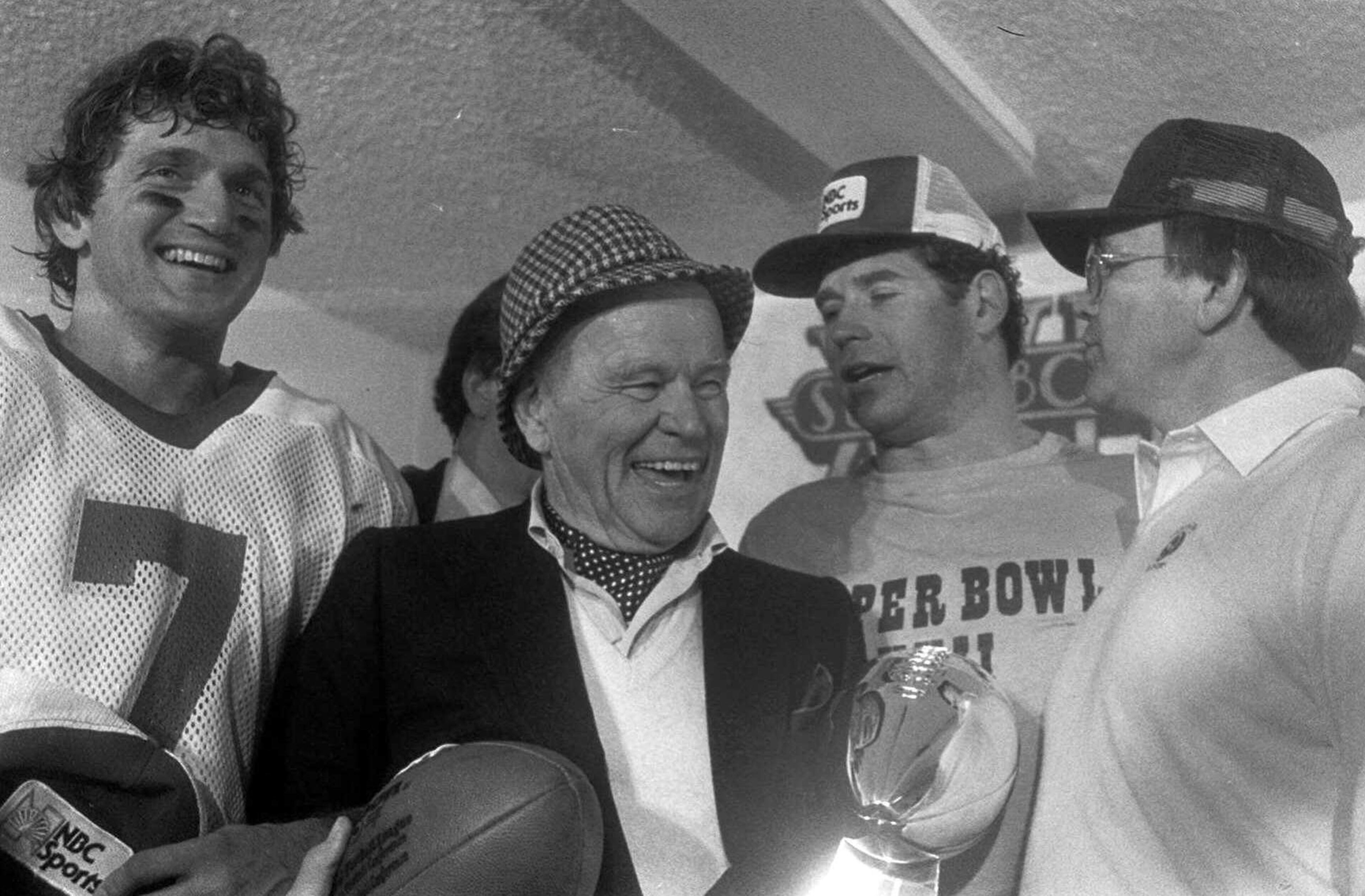FILE -- Washington Redskins owner Jack Kent Cooke, second from left, holds onto the Super Bowl trophy and game ball after the Redskins beat Miami in Super Bowl XVII in Pasadena, Ca., Jan. 31, 1983. Others in the photo are Redskins quarterback Joe Theismann, left, running back John Riggins, second from right, and coach Joe Gibbs. (AP Photo/File)