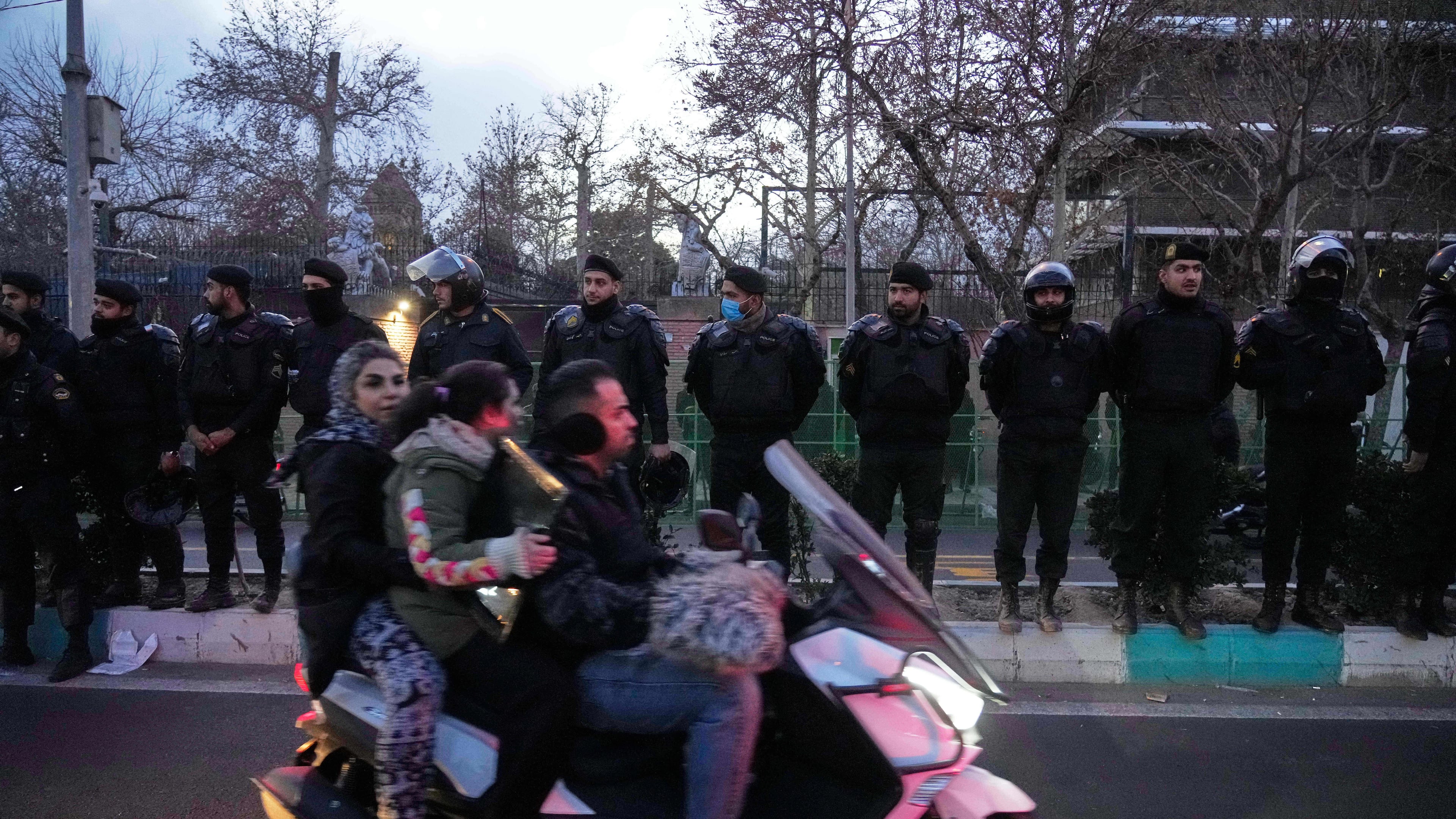 Policemen protect the British Embassy during a protest by hardline supporters of the Iranian government, as people ride on their motorbike in Tehran, Iran, Wednesday, Jan. 14, 2026. (AP Photo/Vahid Salemi)
