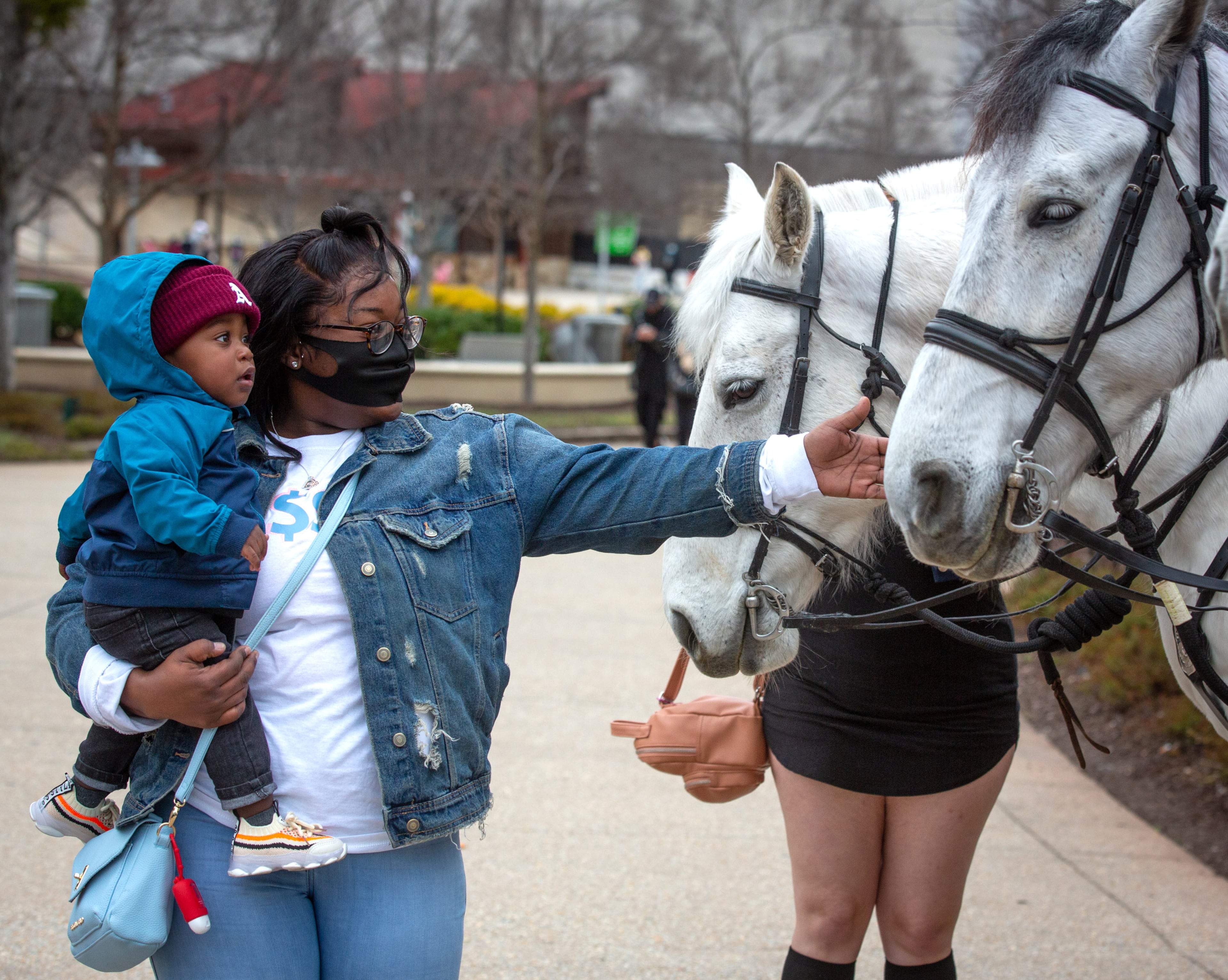Areuna Cater and her son Major Johnson look over the Atlanta Police Mounted Patrol horses near the Georgia Aquarium on Saturday, March 6, 2021. (Photo: Steve Schaefer for The Atlanta Journal-Constitution)