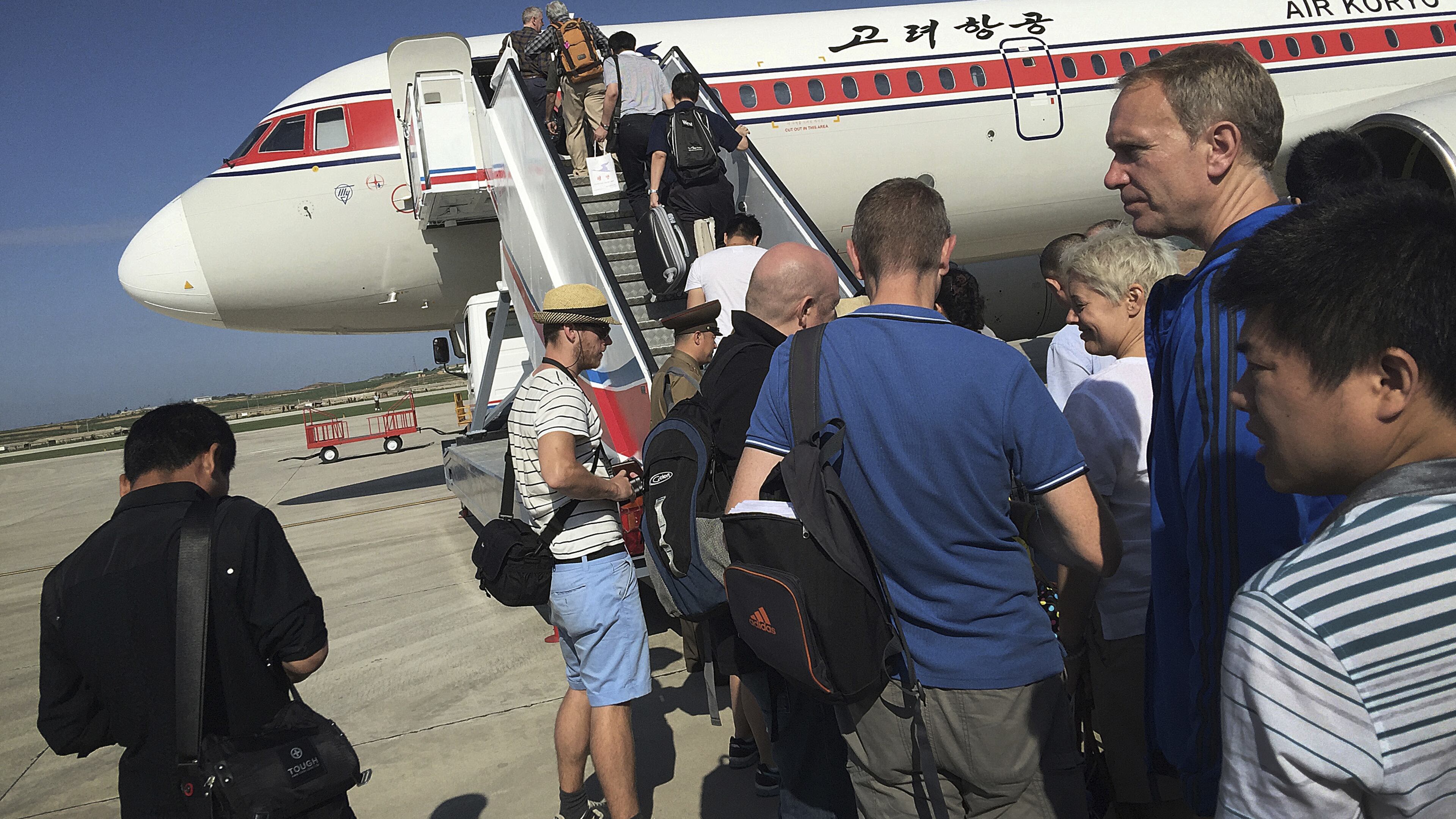 FILE - In this June 27, 2015, file photo, passengers board an Air Koryo plane bound for Beijing, at the Pyongyang International Airport in Pyongyang, North Korea. A proclamation President Donald Trump signed Sunday, Sept. 24, 2017, would suspend all immigrant and non-immigrant visas for North Koreans. But the measure is largely symbolic since most North Koreans in the U.S. are based at the United Nations and certain North Koreans are banned from traveling due to sanctions. (AP Photo/Wong Maye-E, File)