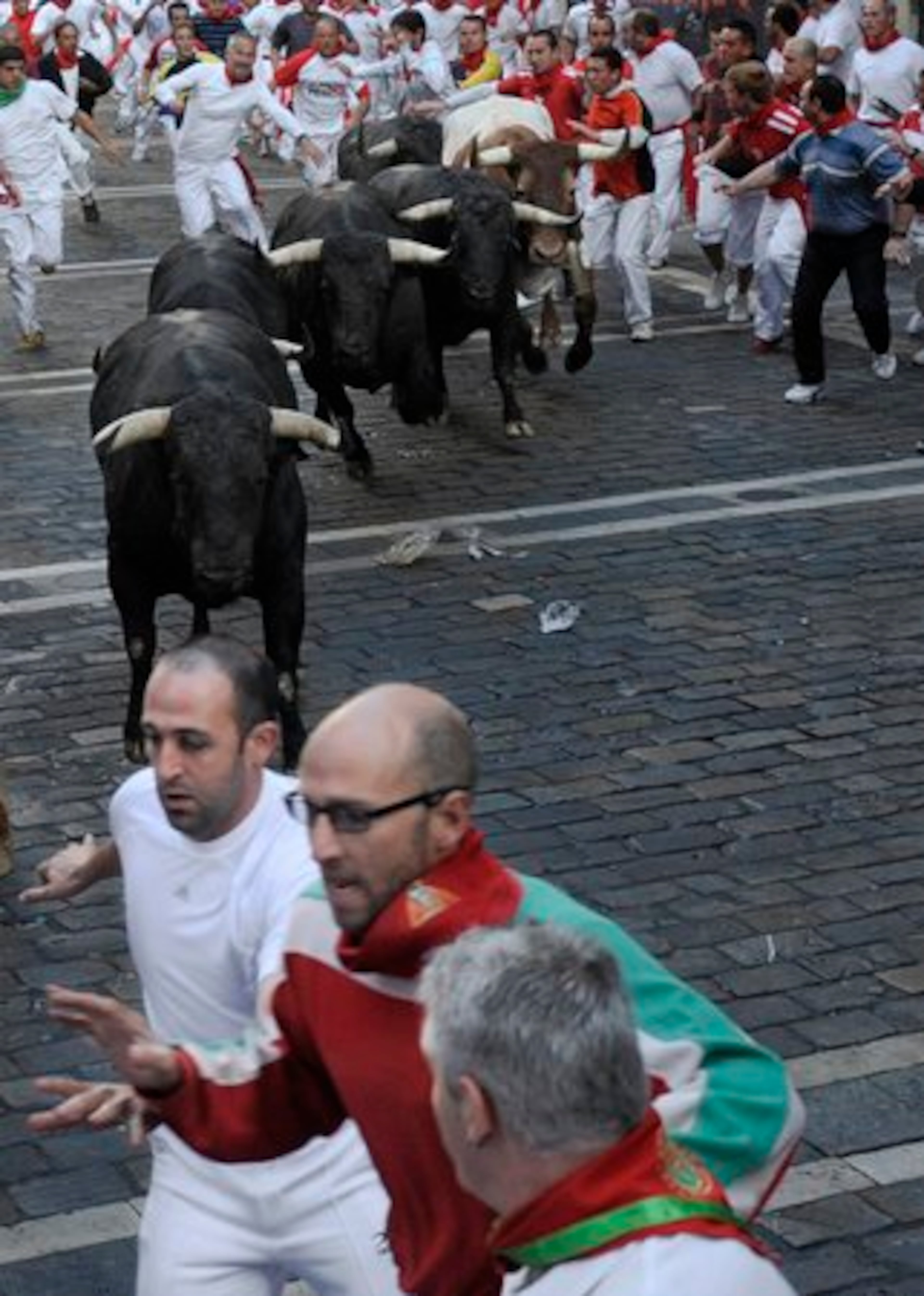 Revelers are chased by Jandilla's ranch fighting bulls on Friday.