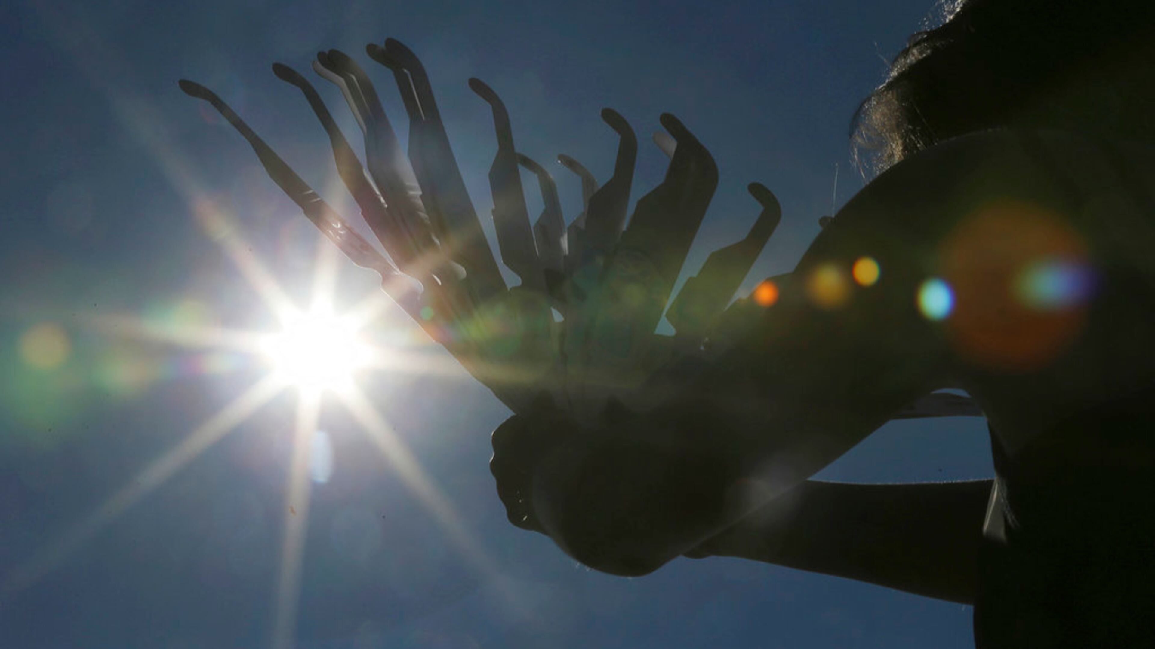Ashley Ann Sander hawks solar eclipse glasses on the side of the road for $10 to tourists approaching Clayton, Ga., Sunday, Aug. 20, 2017. Clayton is in the path of totality in North Georgia. (Curtis Compton/Atlanta Journal-Constitution via AP)