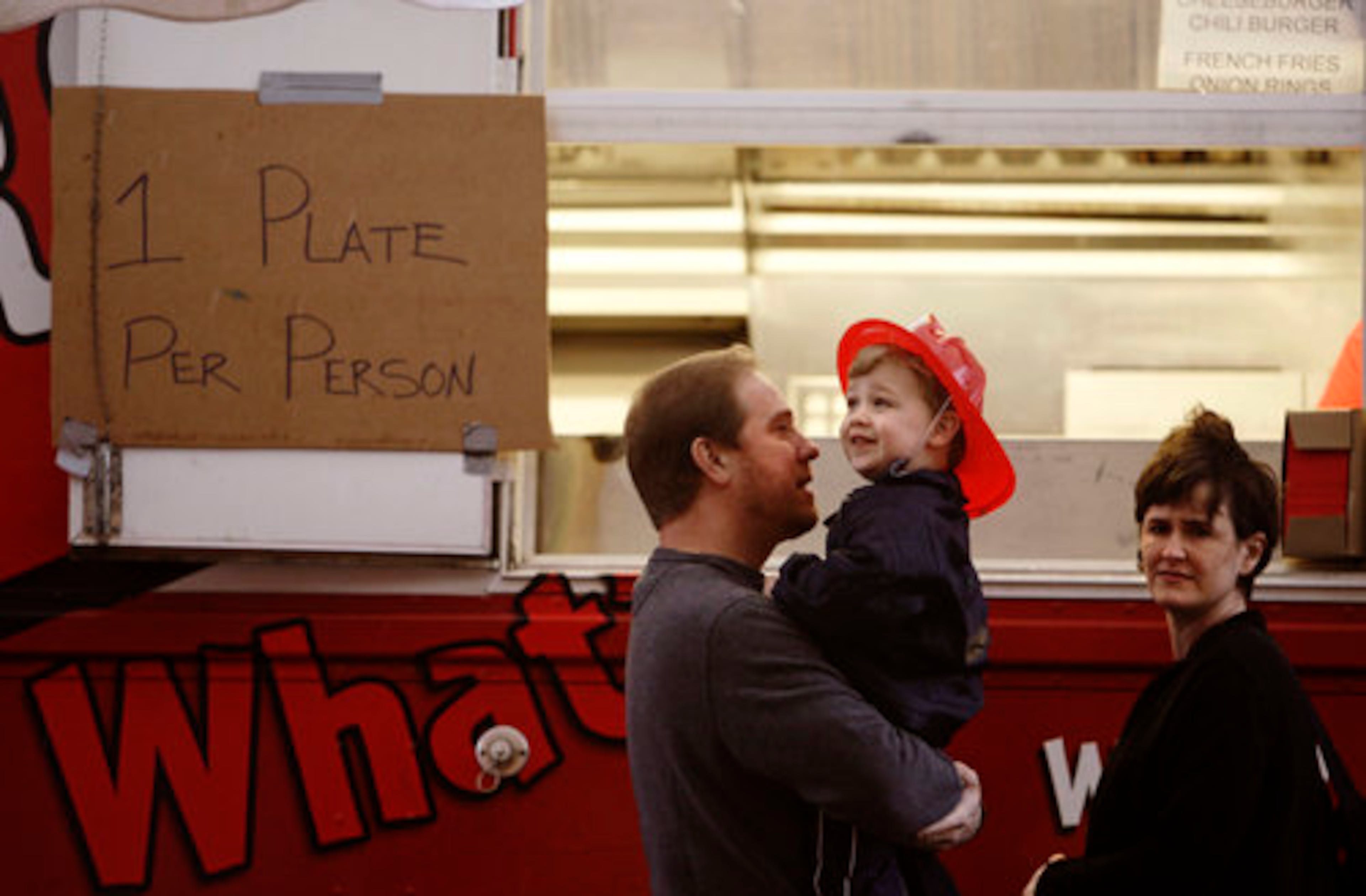Brad Bodenheimer waits for Varsity food with son Max, 2, and wife Aimee.