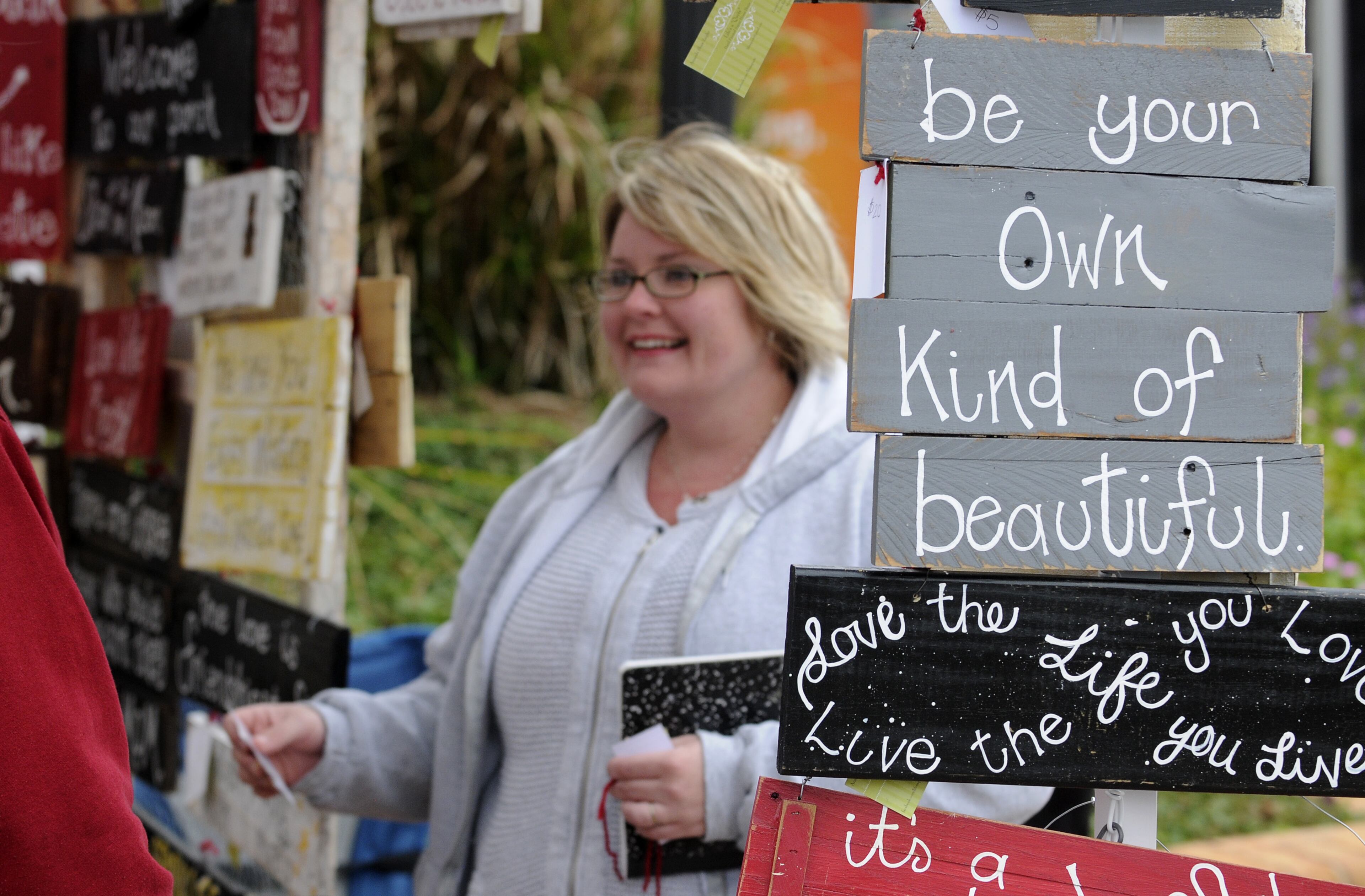 Artist Amanda Shaw Zeigler greets customers at her hand-painted sign booth at the Smyrna Fall Jonquil Festival.