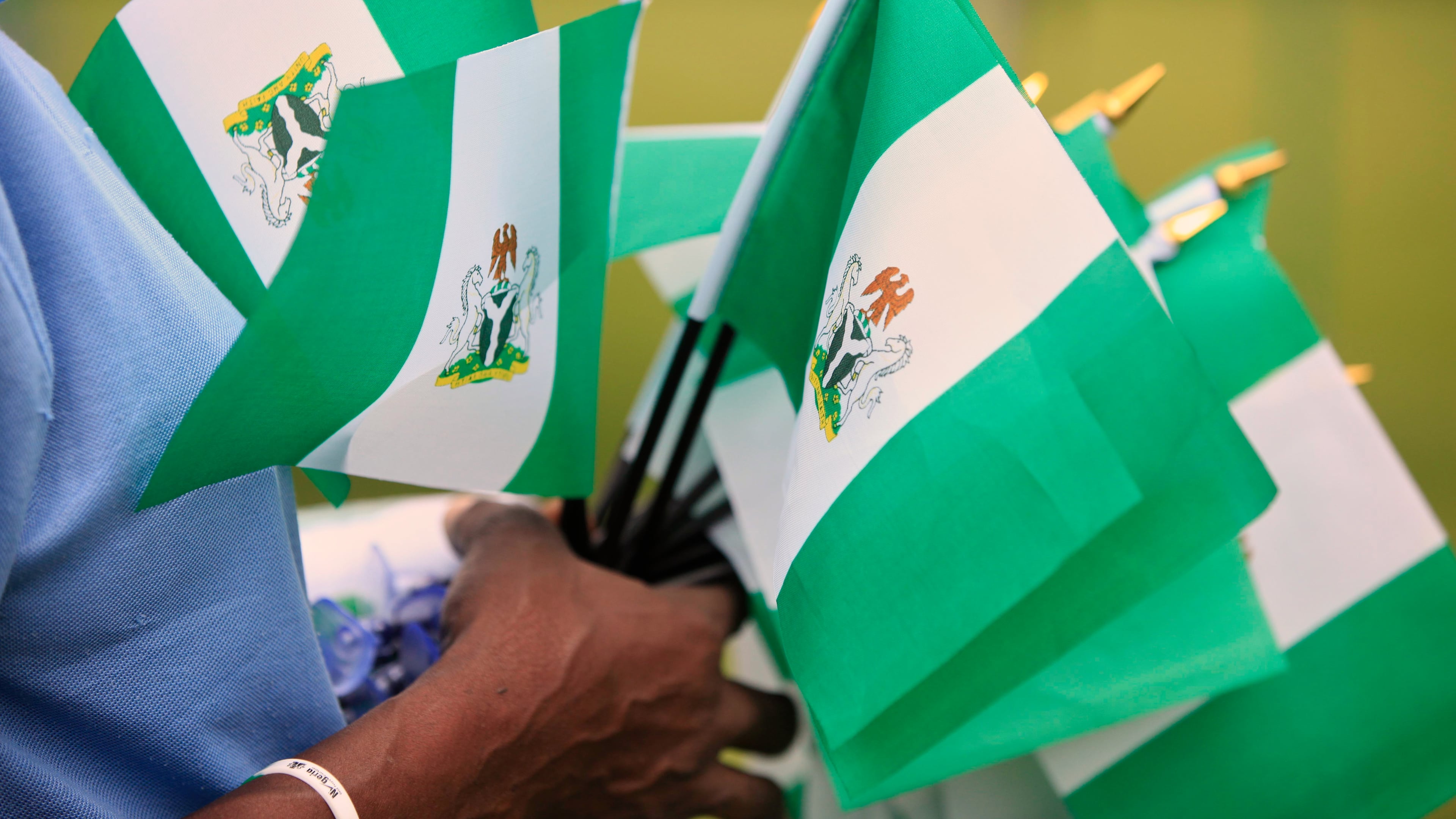FILE - An unidentified woman sells Nigerian national flags during an event to mark Nigeria independence day in Lagos, Nigeria, Oct. 1, 2013. (AP Photo/Sunday Alamba, File)