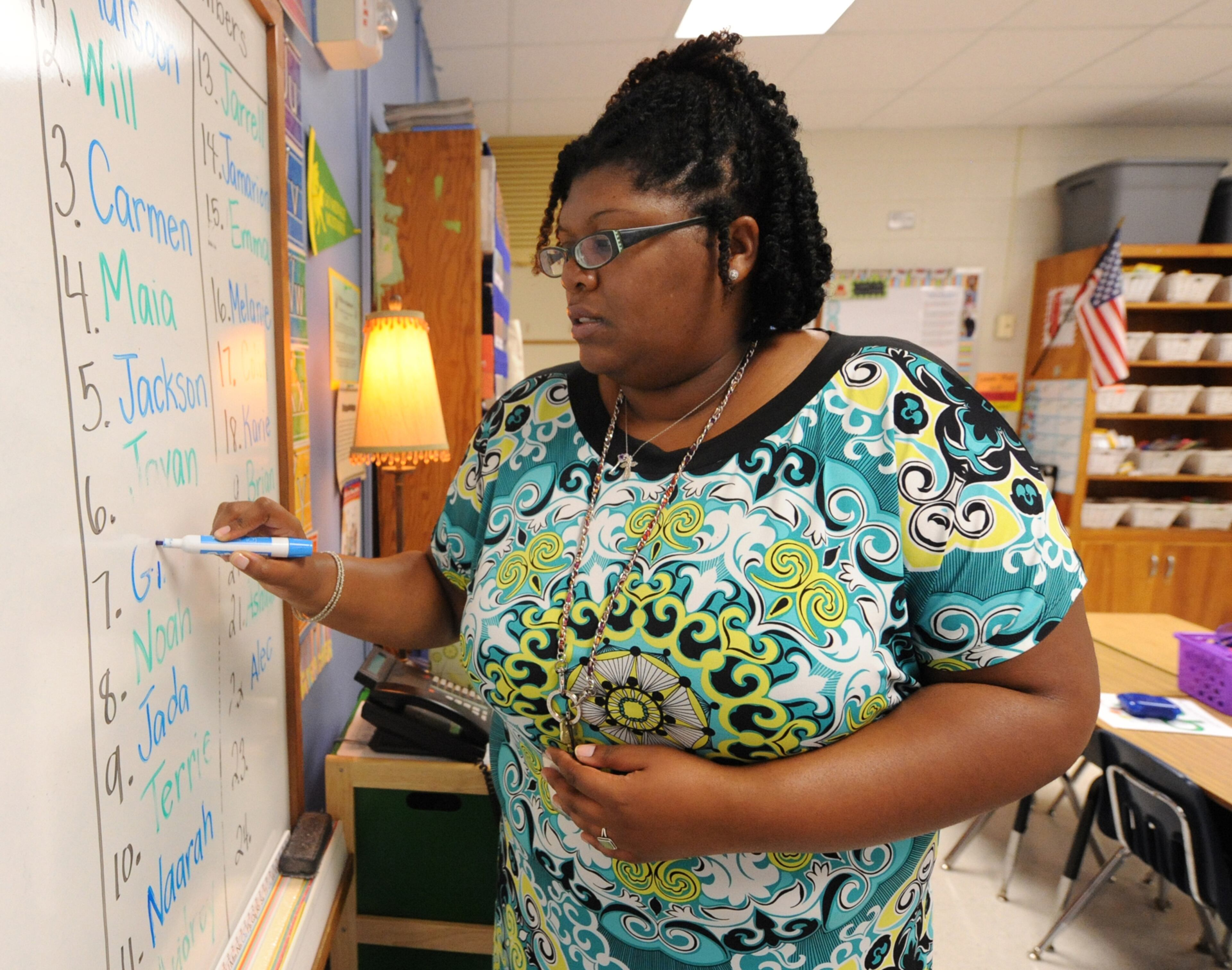 First grade teacher Maegan Donnell writes the names of her students on the board on the first day of school at Midvale Elementary on Monday, August 12, 2013. She has been a teacher for eleven years. JOHNNY CRAWFORD / JCRAWFORD@AJC.COM