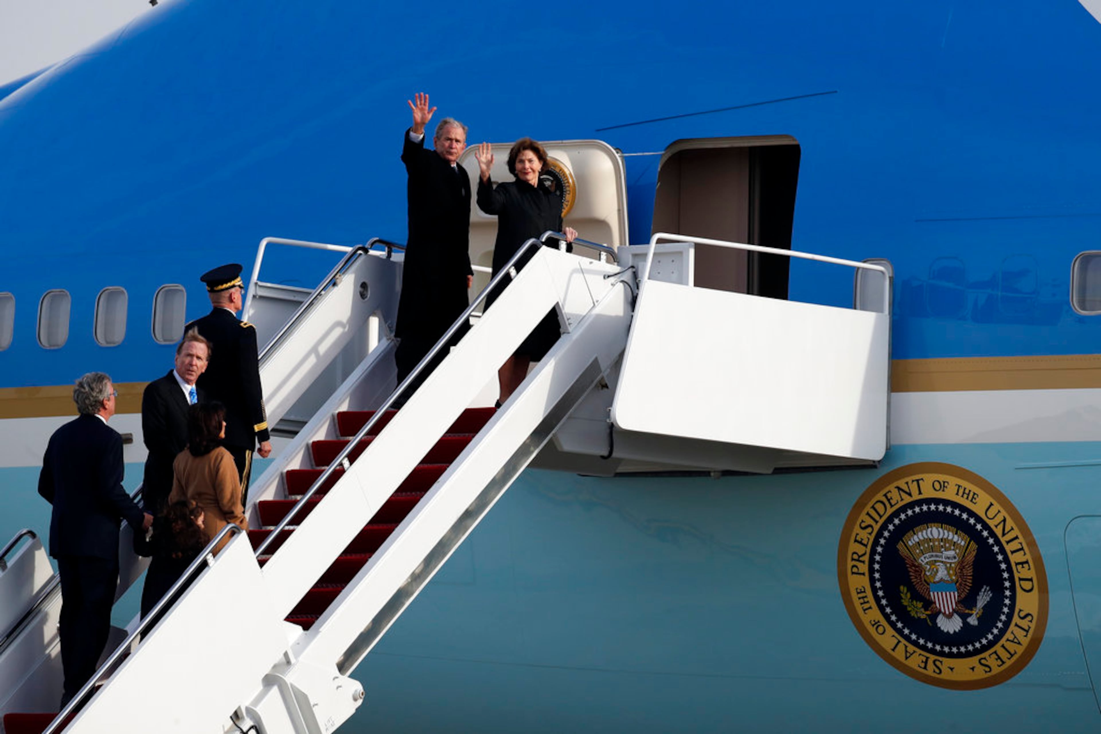Former President George W. Bush and Laura Bush wave as they board Special Air Mission 41 to fly to Houston with the body of former President George H.W. Bush, after a State Funeral Wednesday, Dec. 5, 2018, at Andrews Air Force Base, Md. (AP Photo/Alex Brandon, Pool)