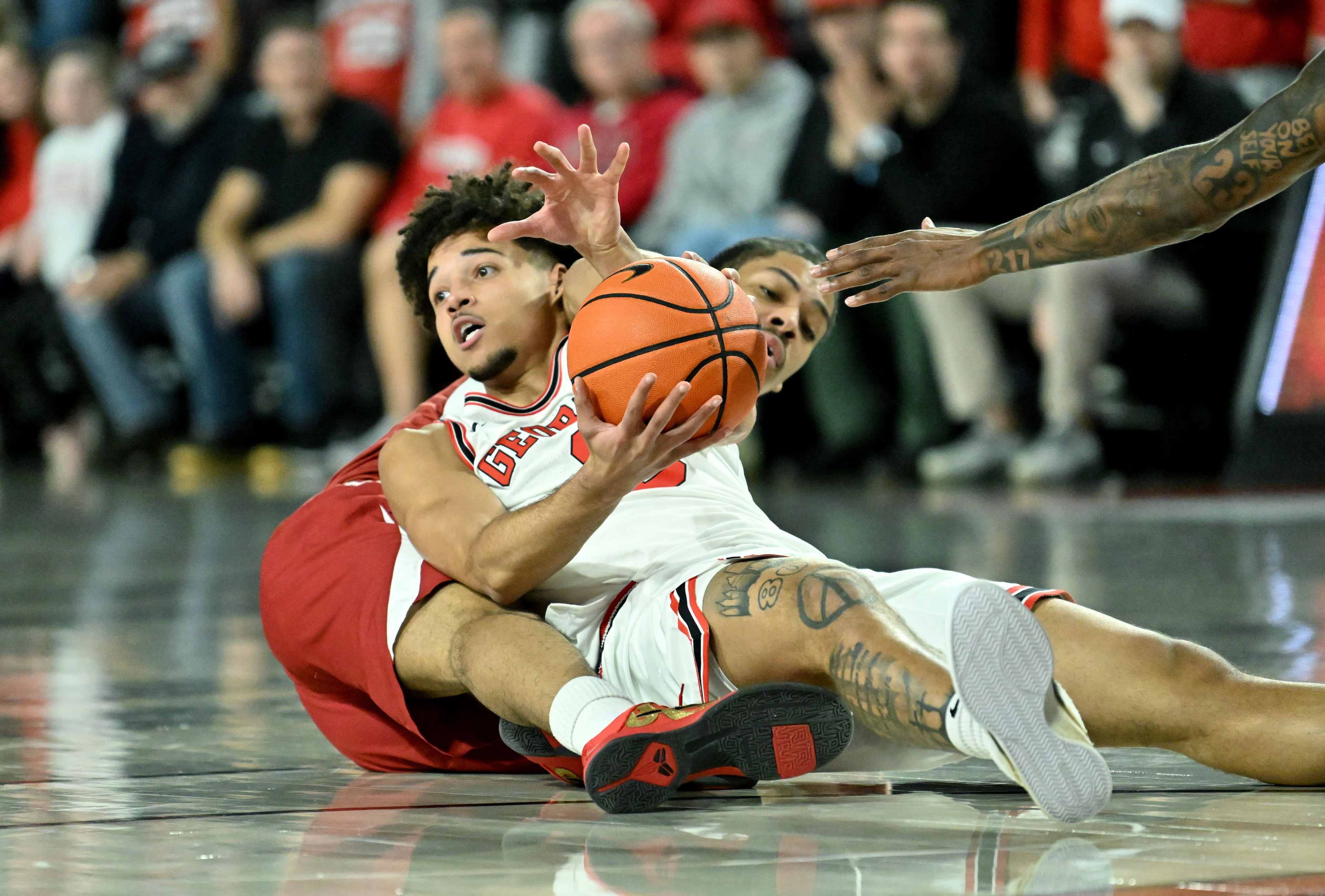 Georgia guard Jordan Ross fights for a loose ball against Arkansas guard Darius Acuff Jr. during the first half in an NCAA college basketball game at Stegeman Coliseum, Saturday, Jan. 17, 2026, in Athens. (Hyosub Shin/AJC)