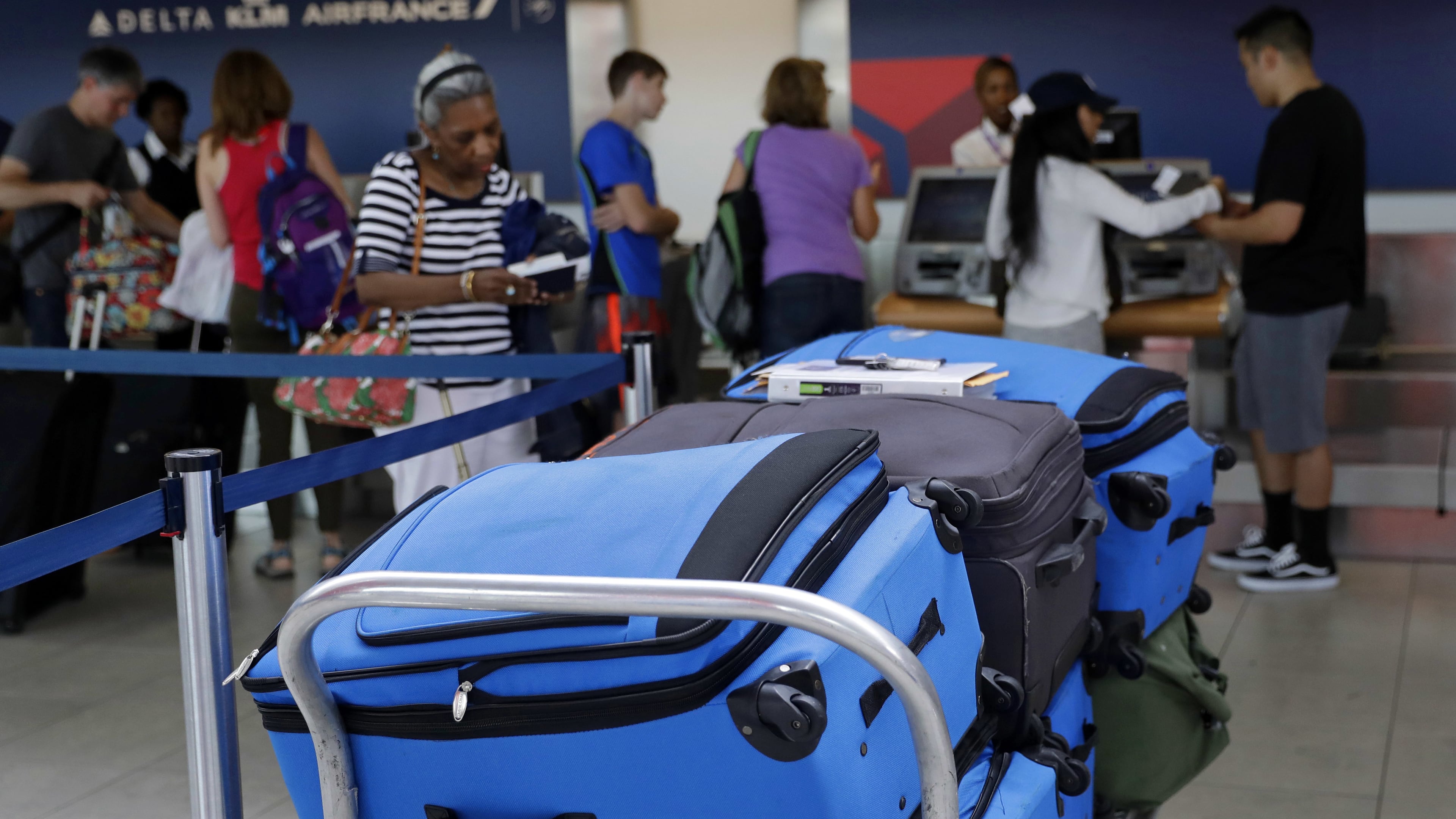 In this July 12, 2016, photo, bags wait to be checked at a Delta Air Lines counter at Baltimore-Washington International Thurgood Marshall Airport in Linthicum, Md. Delta Air Lines is rolling out new technology to better track bags throughout its system. (AP Photo/Patrick Semansky)