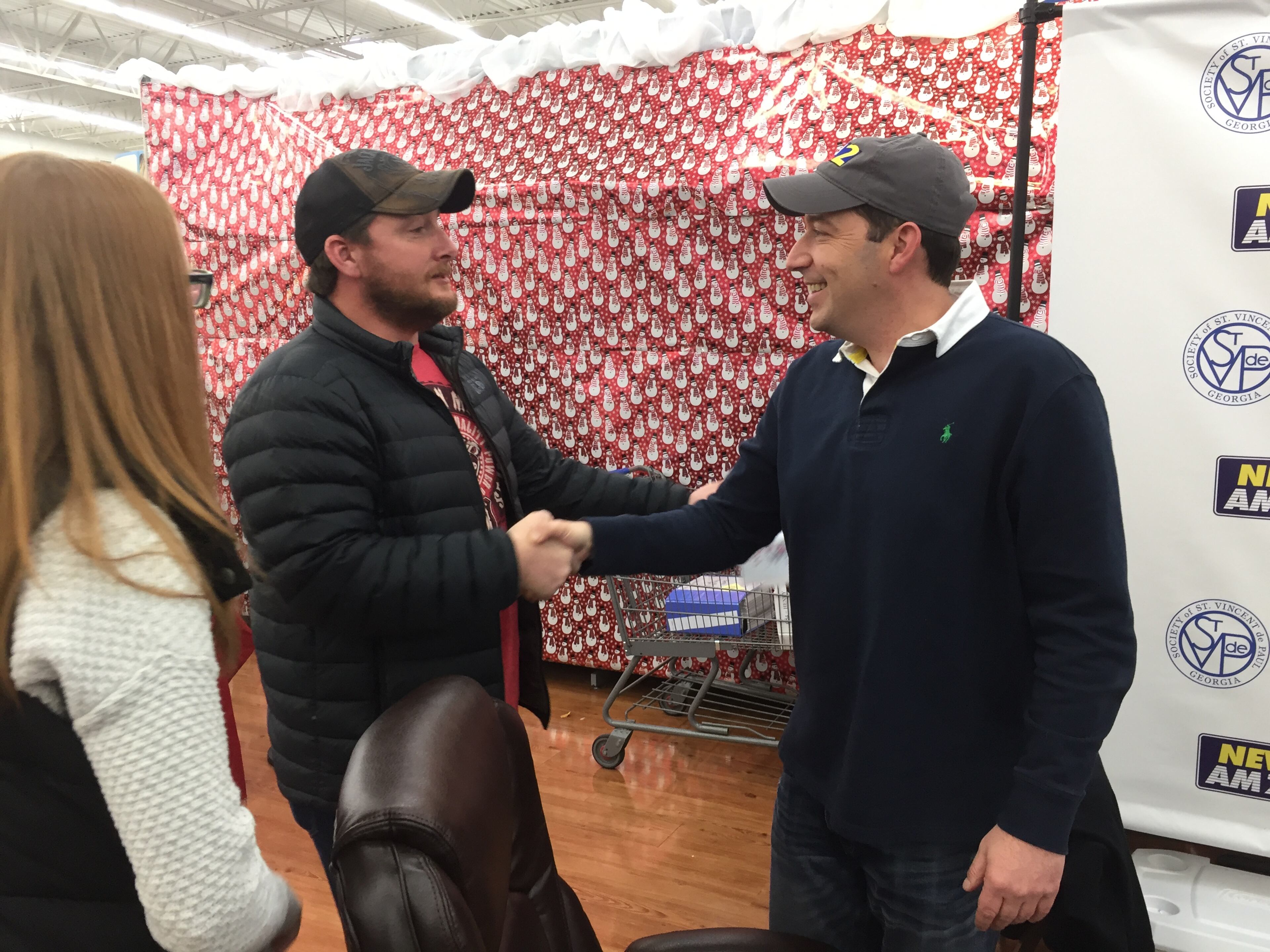 Erin Burch (left) used to work as a producer for Clark Howard's radio show. Mark Arum, talk show host and traffic guy, greets her husband Brock. CREDIT: Rodney Ho/ rho@ajc.com