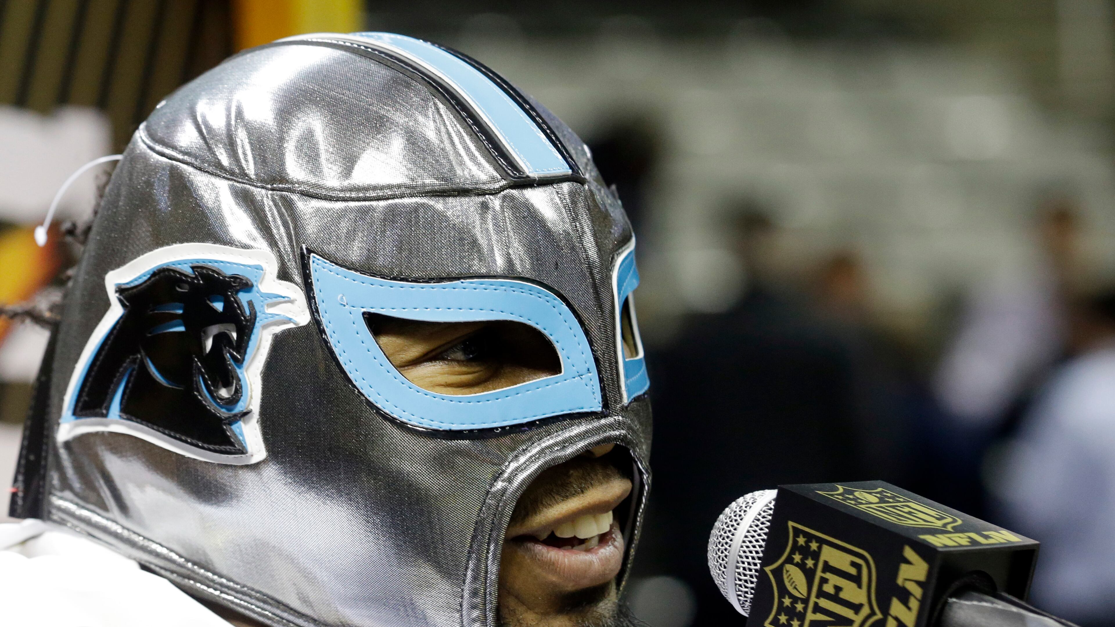 Carolina Panthers' Josh Norman wears a mask as he answers a question during Opening Night for the NFL Super Bowl 50 football game Monday, Feb. 1, 2016, in San Jose, Calif. (AP Photo/Jeff Chiu)