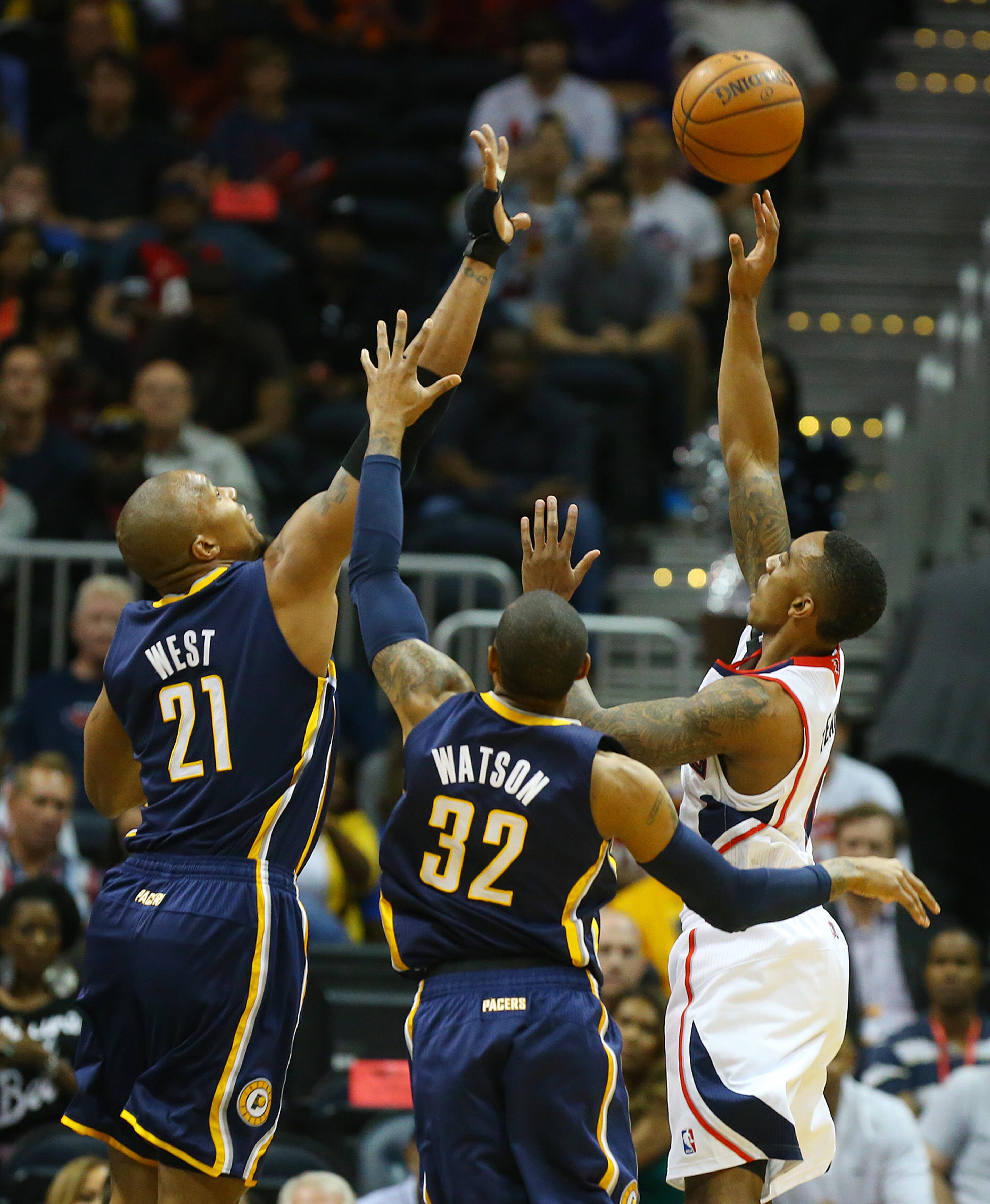 Hawks guard Jeff Teague shoots for 2 points over Pacers defenders Davis West and C.J. Watson during the first half of their NBA playoff game on Thursday, April 24, 2014, in Atlanta. CURTIS COMPTON / CCOMPTON@AJC.COM