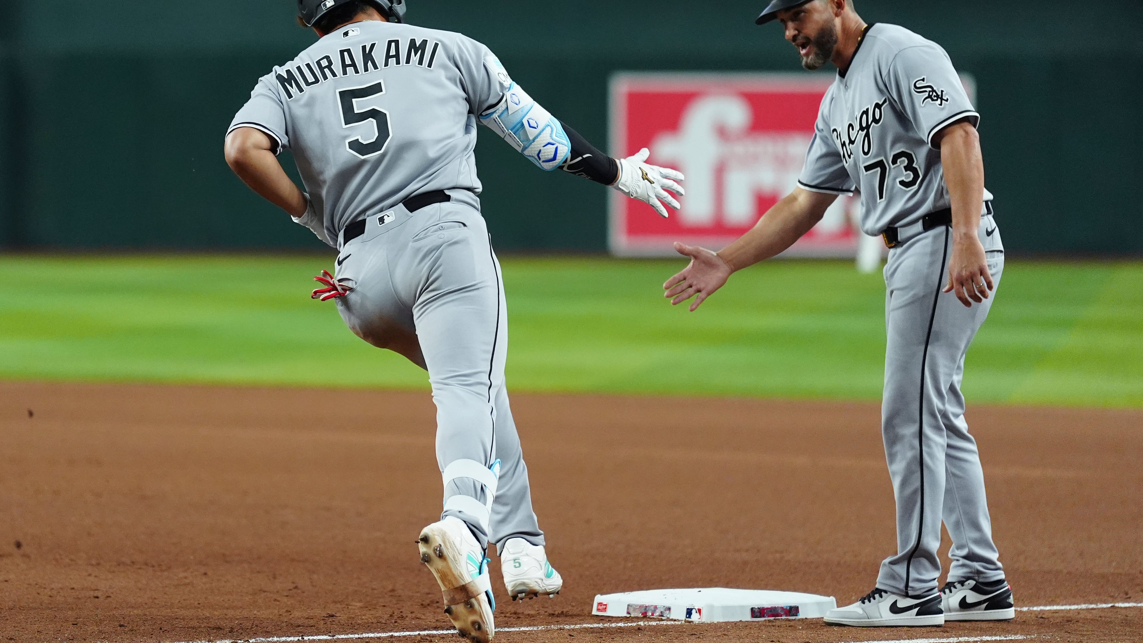 Chicago White Sox's Munetaka Murakami (5), of Japan, celebrates his two-run home run against the Arizona Diamondbacks with White Sox third base coach Jose Leger (73) during the seventh inning of a baseball game, Wednesday, April 22, 2026, in Phoenix. (AP Photo/Ross D. Franklin)