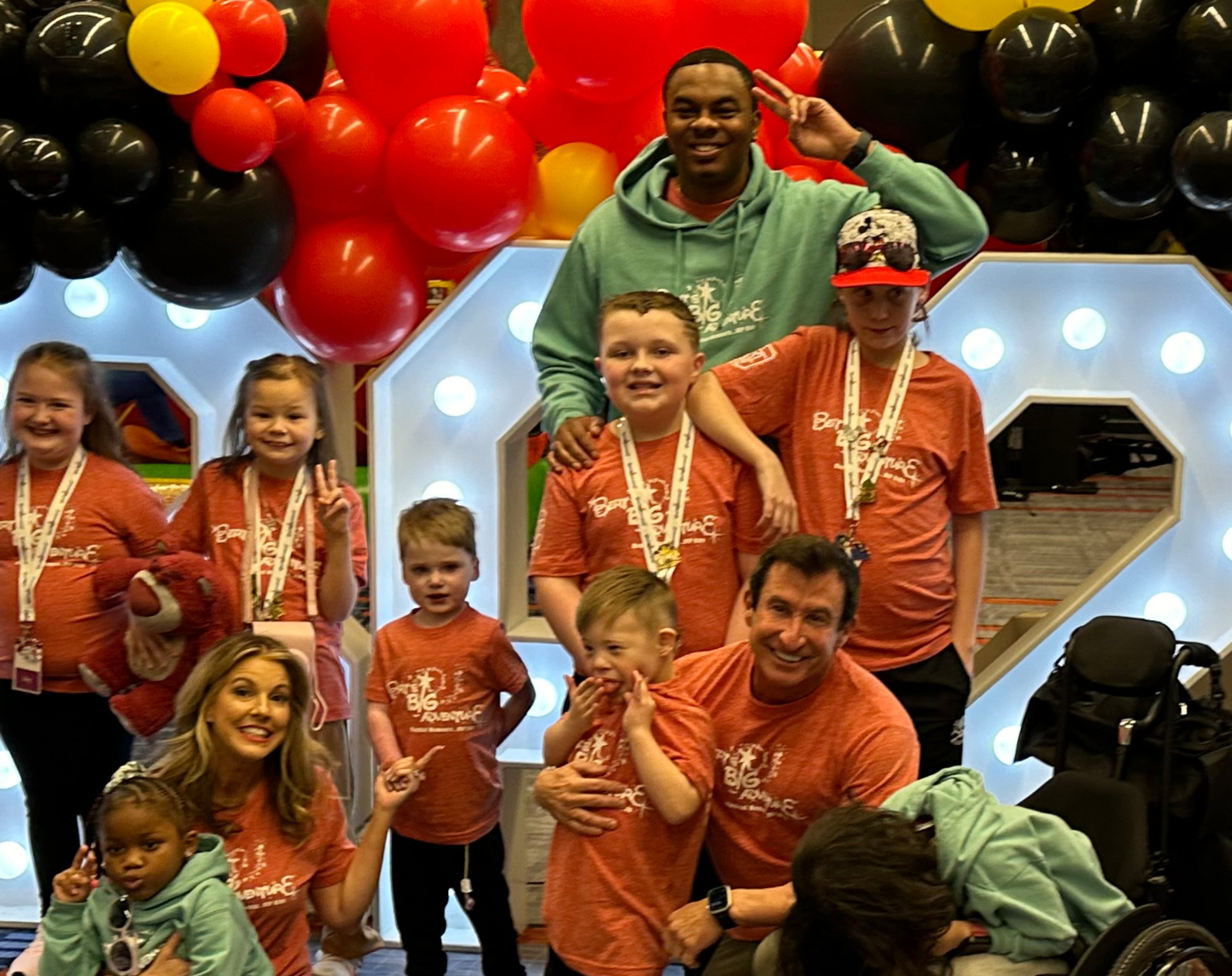 Moe Mitchell (top) hangs with kids during a Bert's Big Adventure kickoff party in Atlanta in February 2024. (Rodney Ho/AJC 2024)