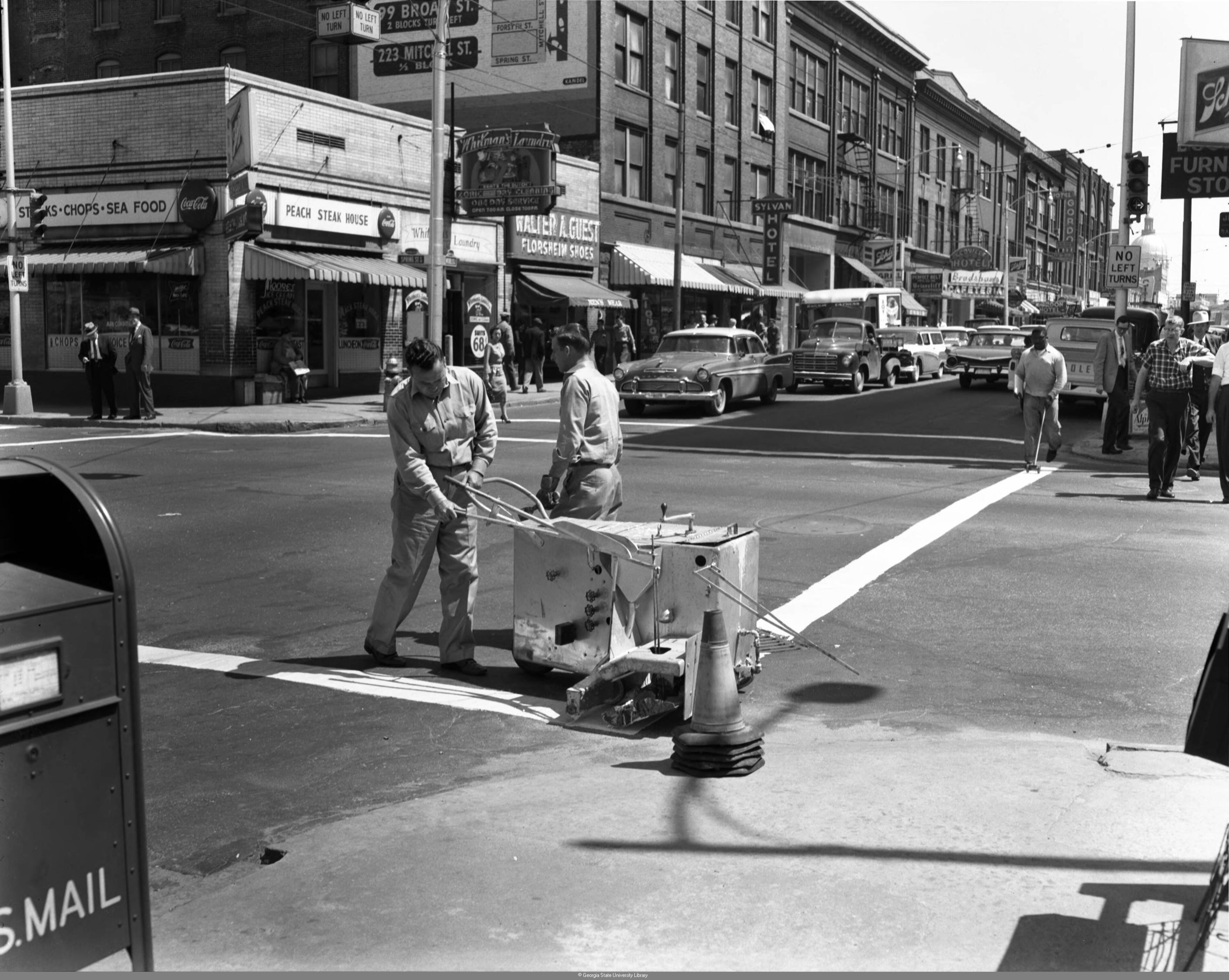 Men painting a crosswalk on Spring Street in 1960. Lane Brothers Commercial Photographers. Special Collections and Archives, Georgia State University Library