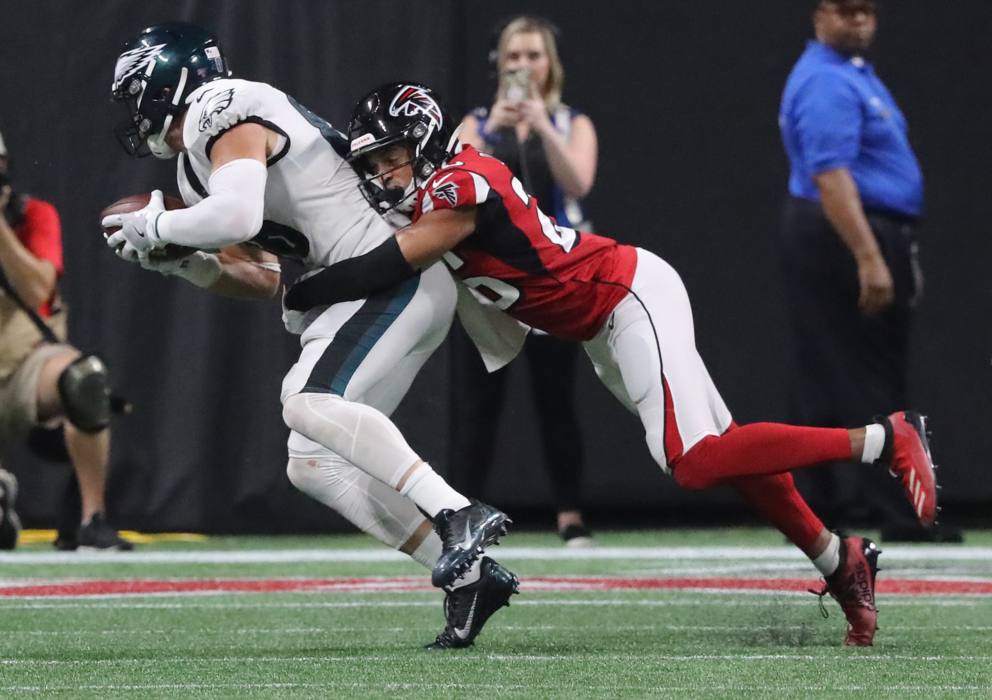 Falcons cornerback Isaiah Oliver tackles Philadelphia Eagles tight end Zach Ertz just short of the first down on a fourth down attempt. Curtis Compton/ccompton@ajc.com