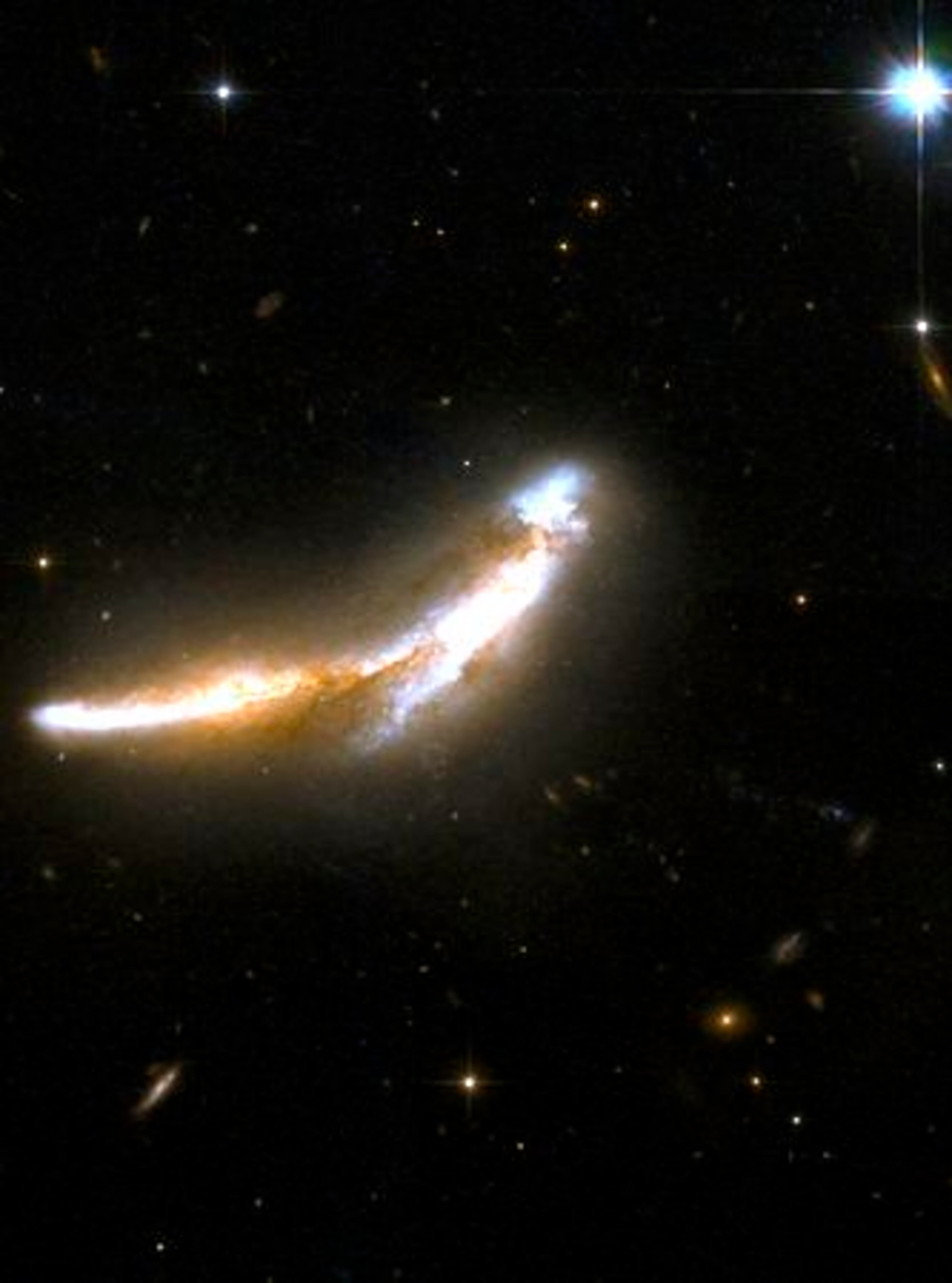 The NGC 6670 pair of overlapping edge-on galaxies. Scientists believe that NGC 6670 has already experienced at least one close encounter and is now in the early stages of a second. The nuclei of the two galaxies are approximately 50,000 light-years apart. NGC 6670 glows in the infrared with more than a hundred billion times the luminosity of the sun and is thought to be entering a starburst phase. The pair is located some 400 million light-years away from Earth.