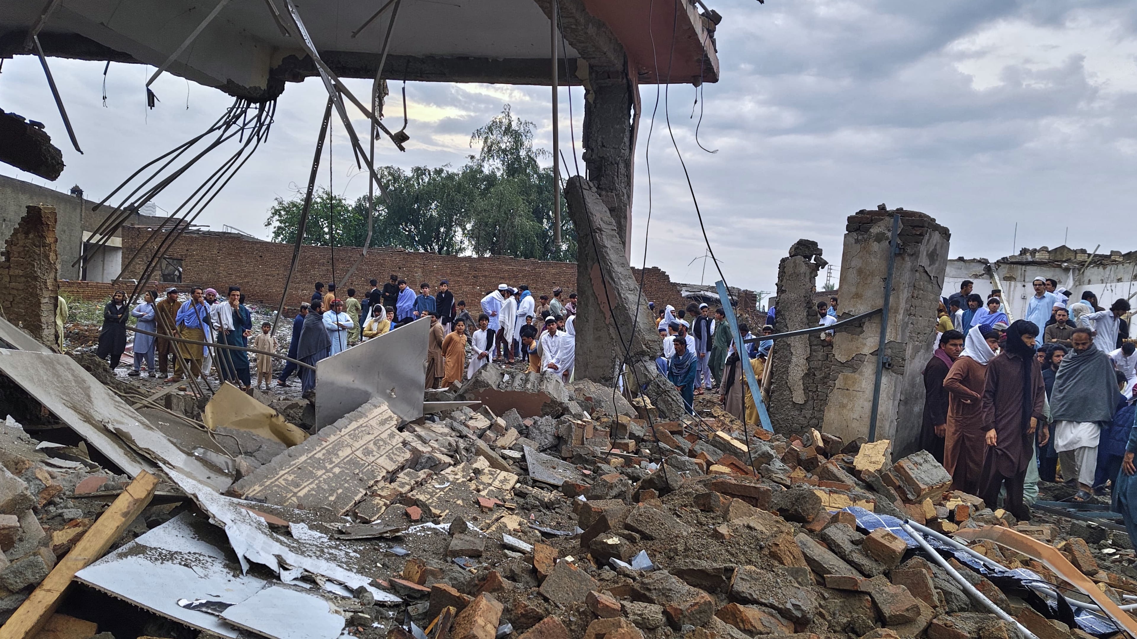 Local residents look at a damaged area of a police station after an overnight deadly bombing in the Bannu district of northwestern Pakistan, Friday, April 3, 2026. (AP Photo/Amaad Khattak)