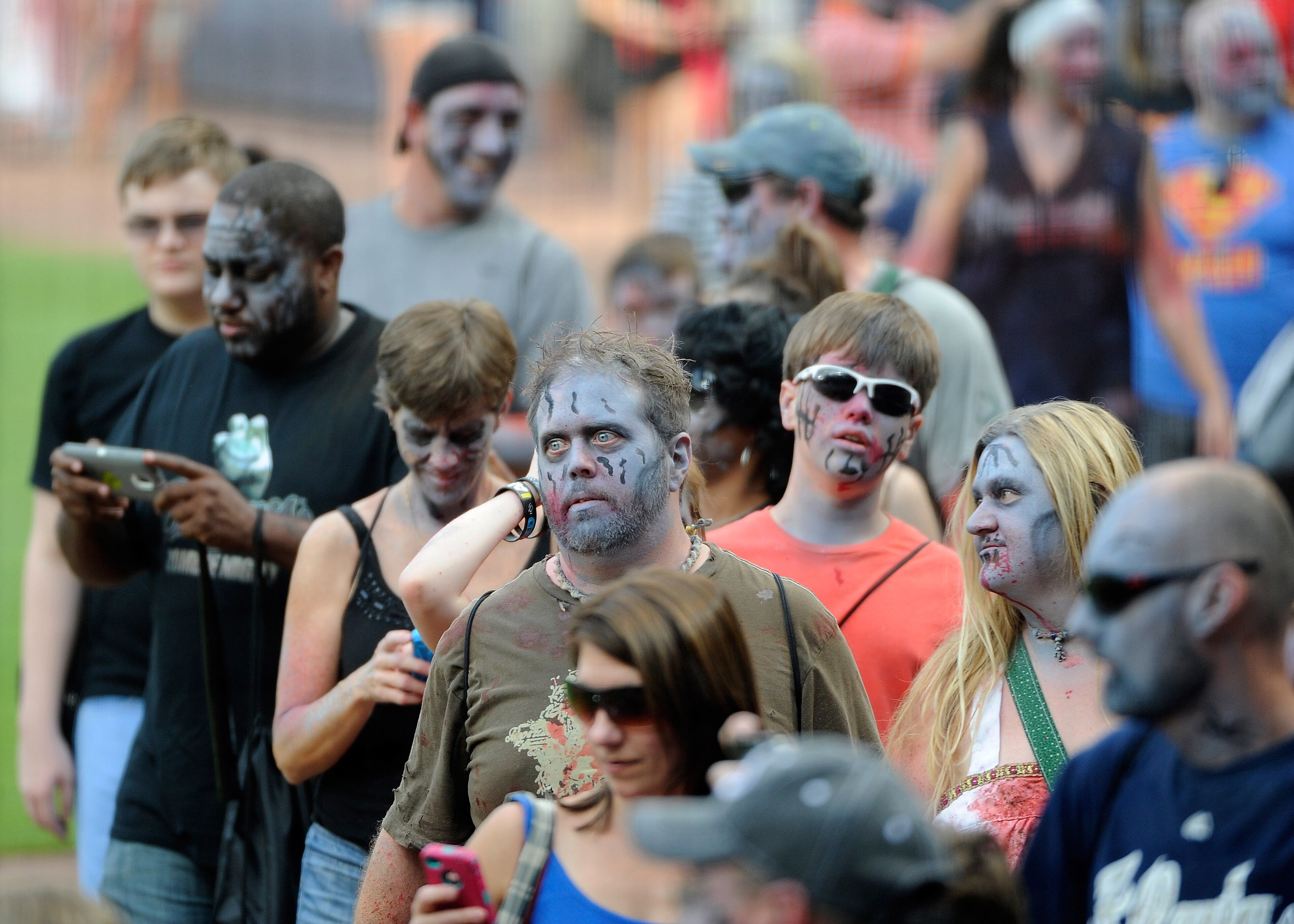 Atlanta Braves fans participate in the team's annual Zombie Walk prior to the first inning of a baseball game against the Oakland Athletics, Friday, Aug. 15, 2014, in Atlanta. Several zombie-based television shows including "The Walking Dead" are filmed in the Atlanta area. (AP Photo/David Tulis)