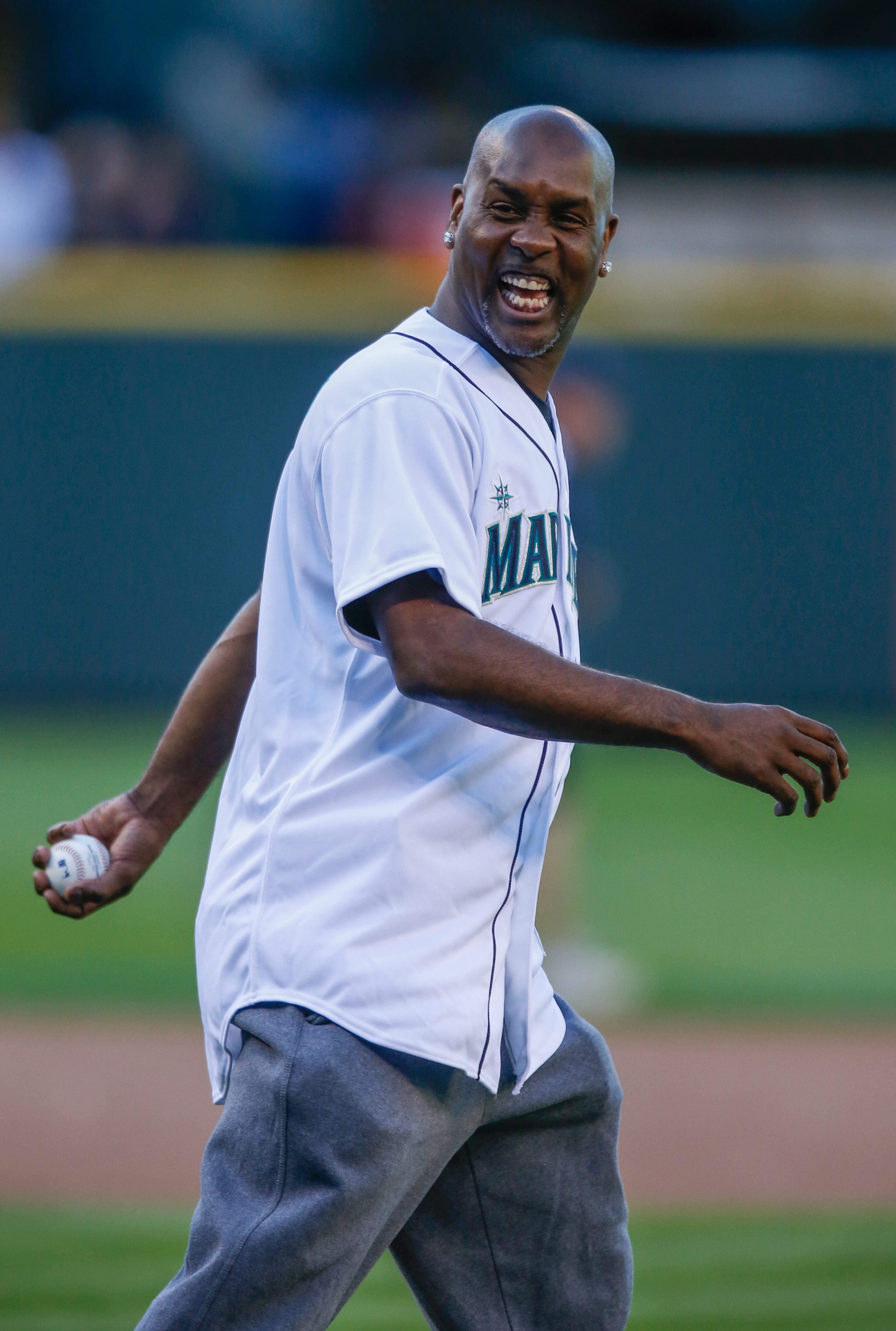 Former Seattle SuperSonics NBA great Gary Payton heads out to the mound to throw out the ceremonial first pitch prior to the game between the Seattle Mariners and the Minnesota Twins at Safeco Field on July 26, 2013 in Seattle, Washington.