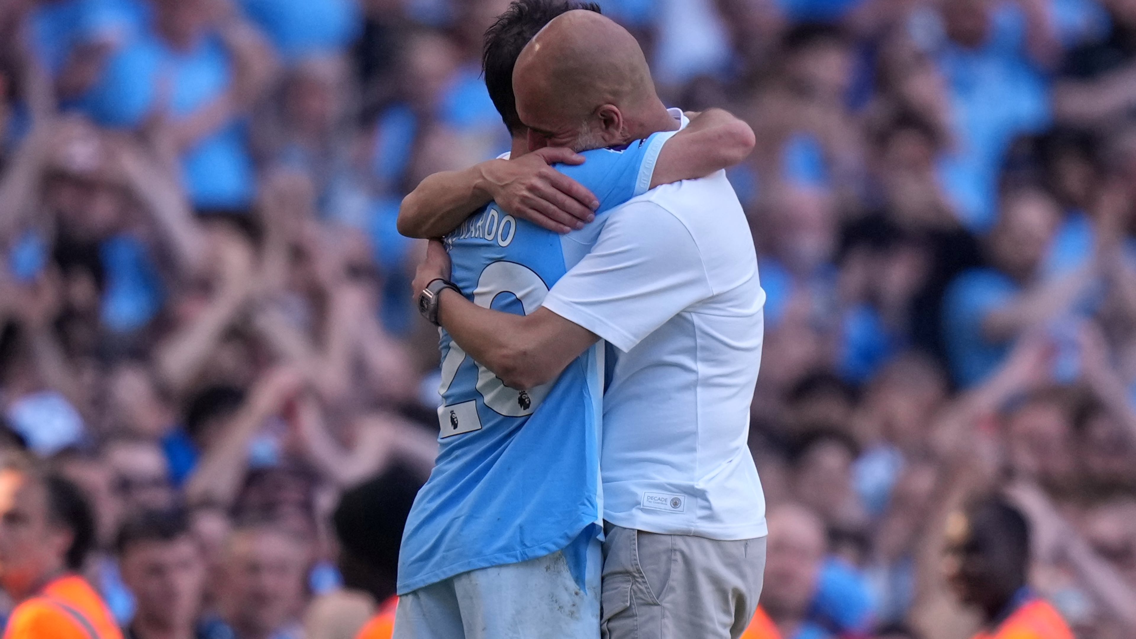 Manchester City's head coach Pep Guardiola hugs Manchester City's Bernardo Silva as he played last match for the team during a Premier League soccer match between Manchester City and Aston Villa in Manchester, England, Sunday, May 24, 2026. (AP Photo/Alastair Grant)