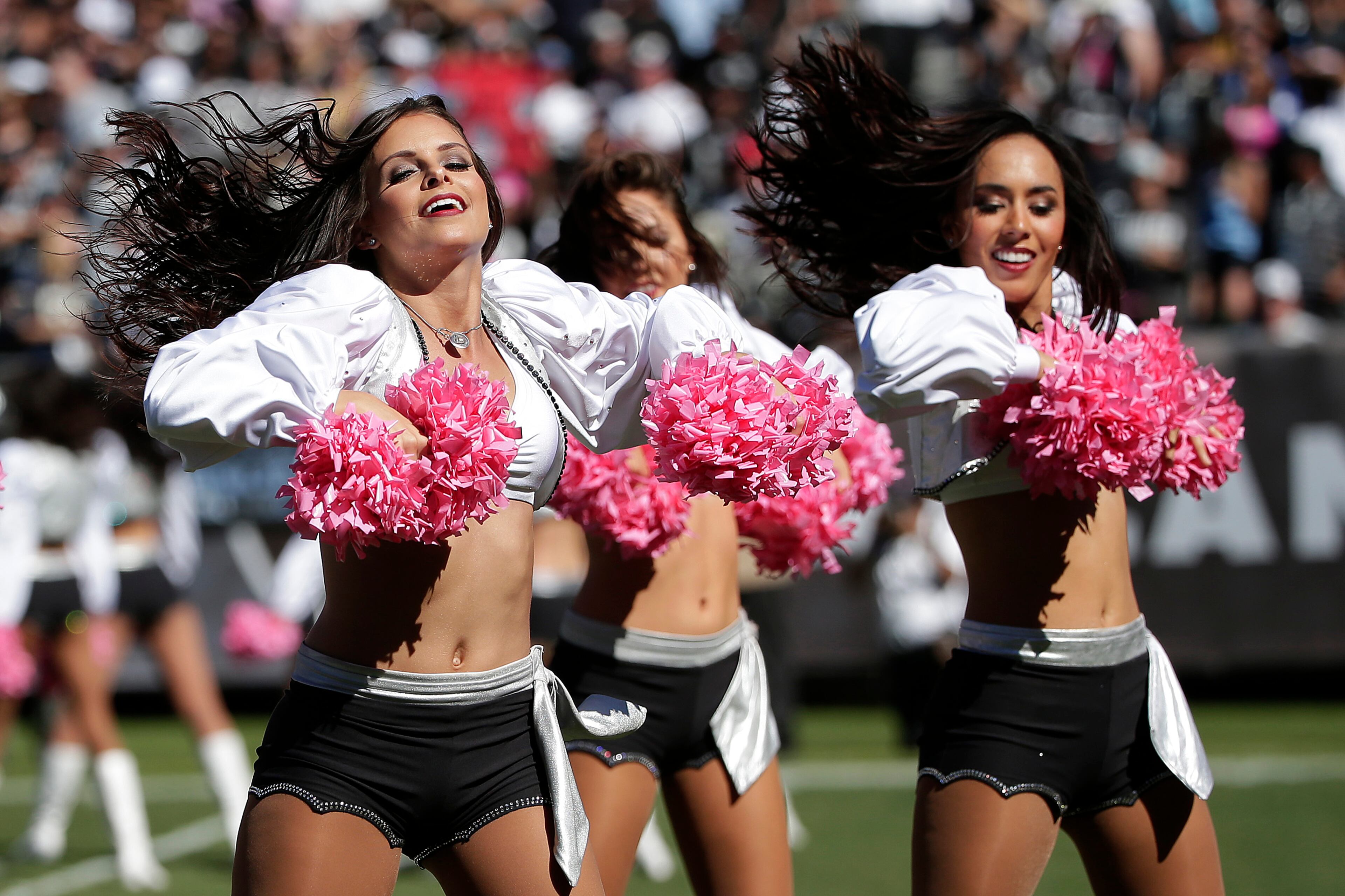 Oakland Raiders cheerleaders perform with pink pom poms for breast cancer awareness during the first half of an NFL football game against the San Diego Chargers in Oakland, Calif., Sunday, Oct. 12, 2014. (AP Photo/Marcio Jose Sanchez)
