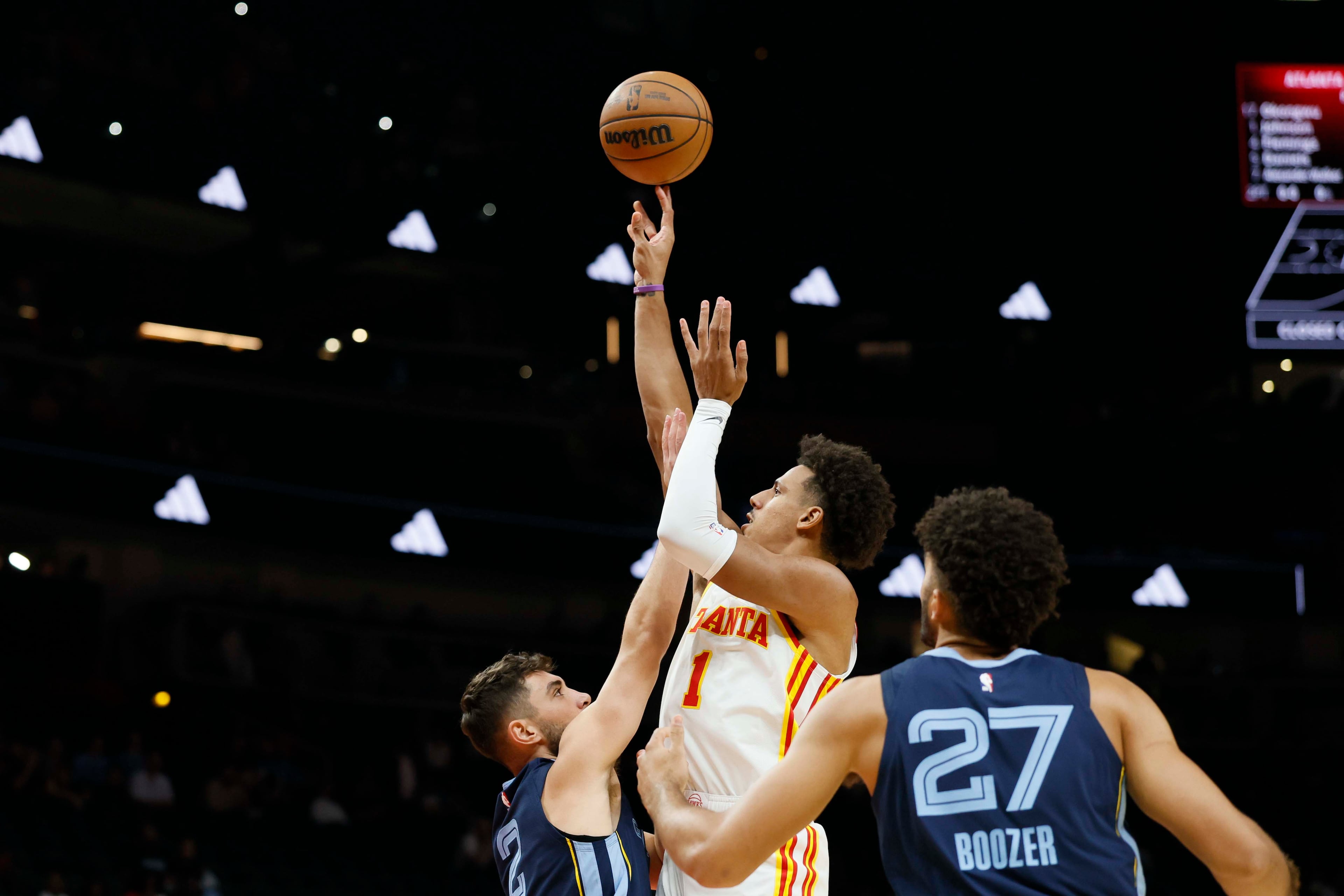 Atlanta Hawks forward Jalen Johnson attempts to shoot under pressure from Memphis Grizzlies guard/forward Ty Jerome (left) in the first half of a preseason NBA game against the Memphis Grizzlies at State Farm Arena in Atlanta on Monday, Oct. 5, 2026. (Miguel Martinez/AJC)