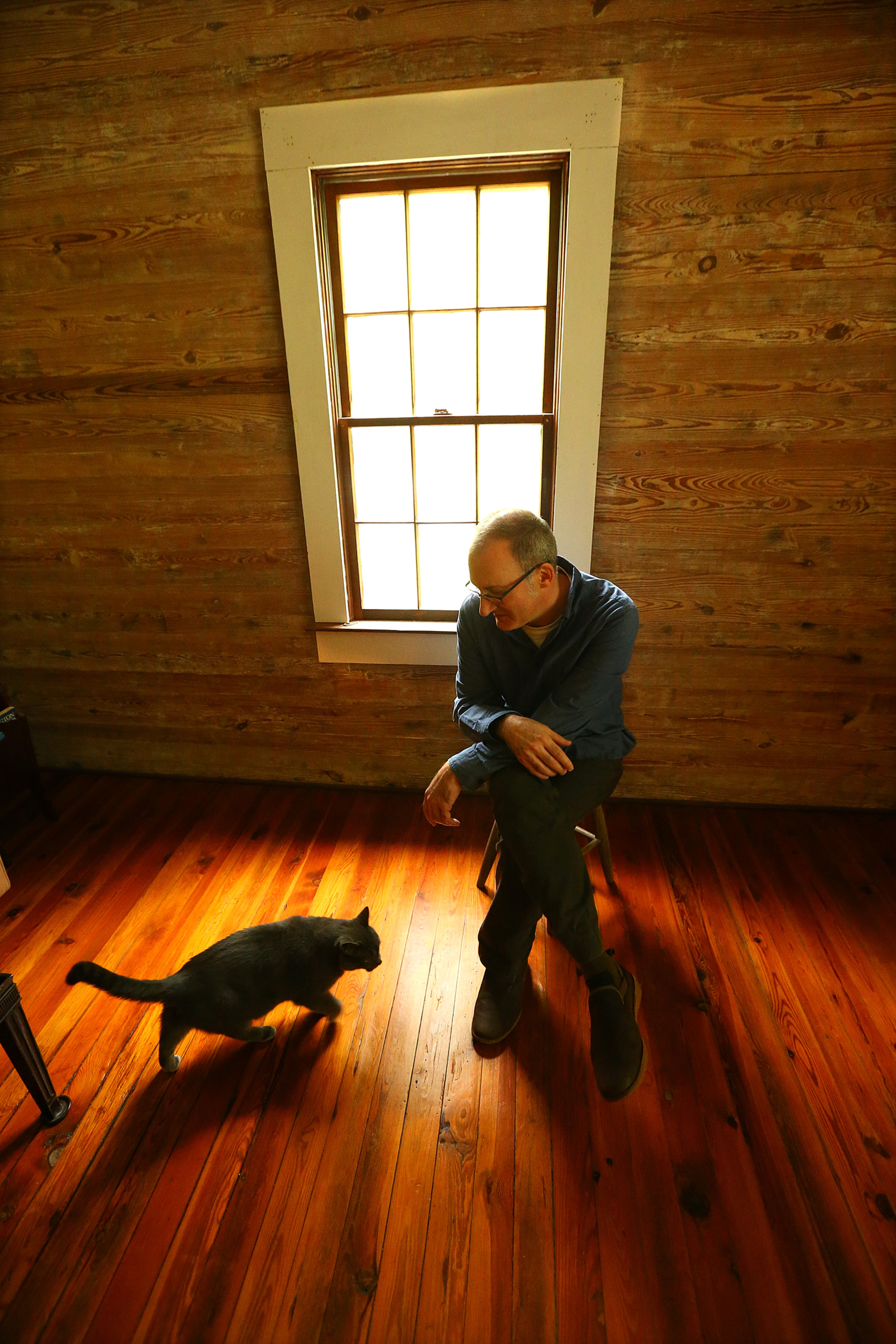 Paul Cooper and his cat Jupiter inside the 1870 home of his grandmother Miss Besse Cooper on Monday, May 19, 2014, in Monroe. Cooper was the oldest person in the world until she died at the age of 116 years and 100 days in 2012. Her 50 acre farm and home has been in the family since 1926 making for a dispute among her heirs on whether to sell the property. Paul Cooper wants to turn it into a park under the Besse Brown Cooper Foundation. CURTIS COMPTON / CCOMPTON@AJC.COM