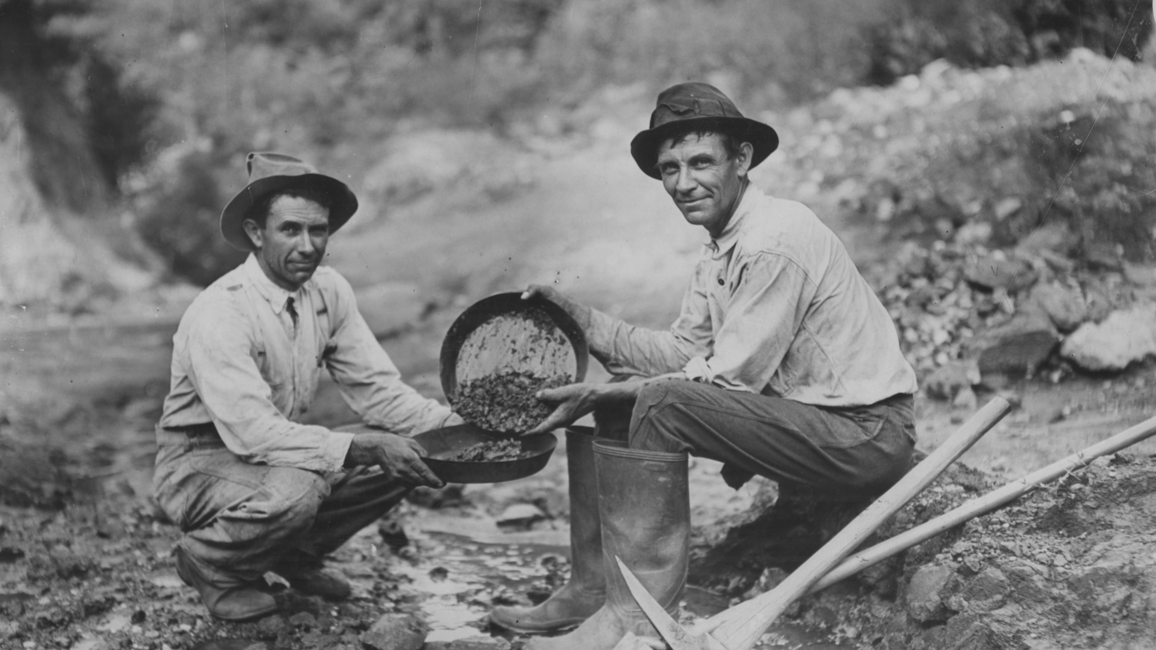 Original caption: "1933 -- The Jenkins brothers of Dahlonega, Tom (left) and William, busy with their gold pans in the famed mining section around their home. There was twenty-five cents' worth of ore in the gravel which William scooped up in his pan."