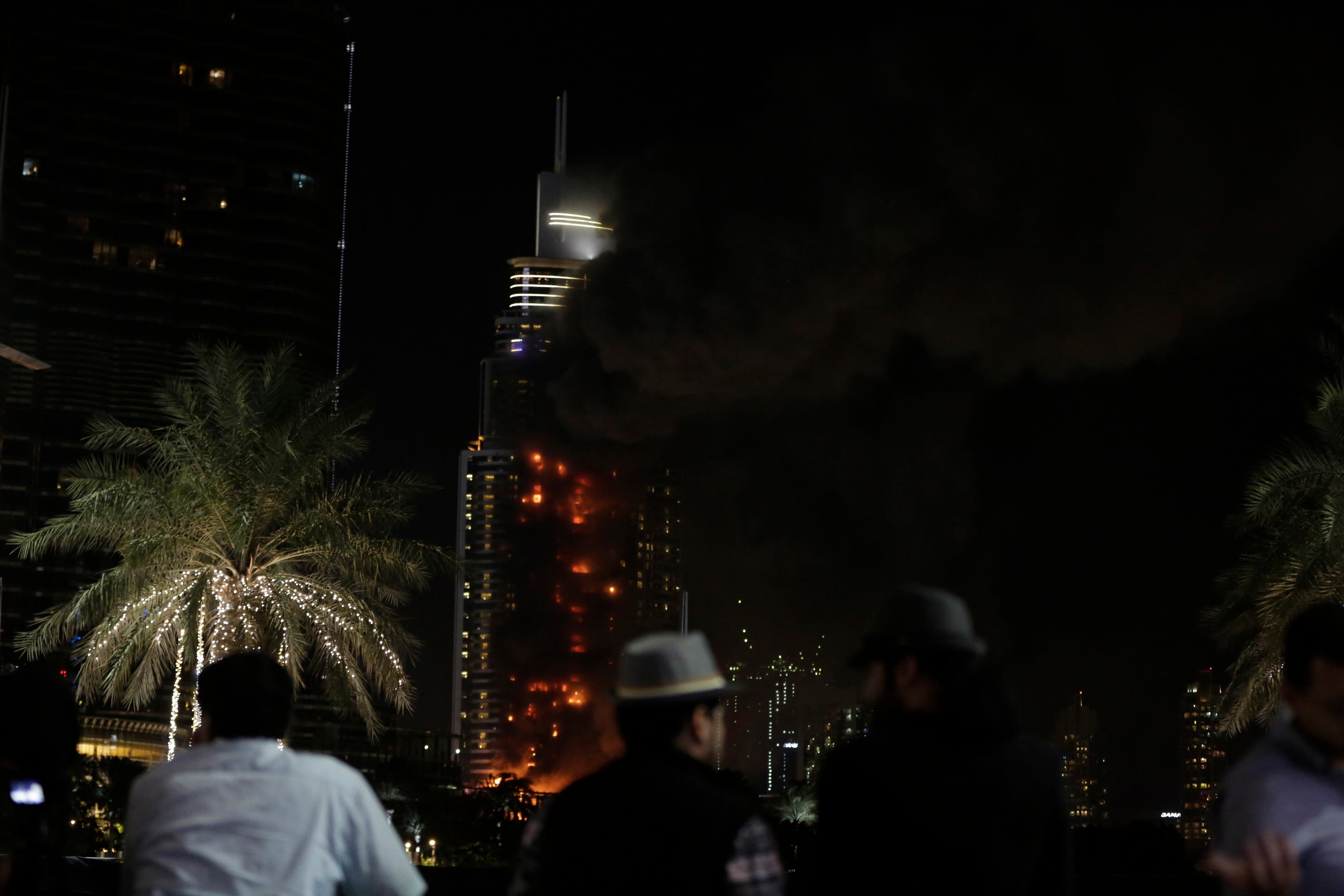 Smoke and flames pouring from a residential building, which also contains the Address Downtown Hotel, in Dubai, United Arab Emirates, Thursday evening, Dec. 31, 2015. (AP Photo/Sunday Alamba)
