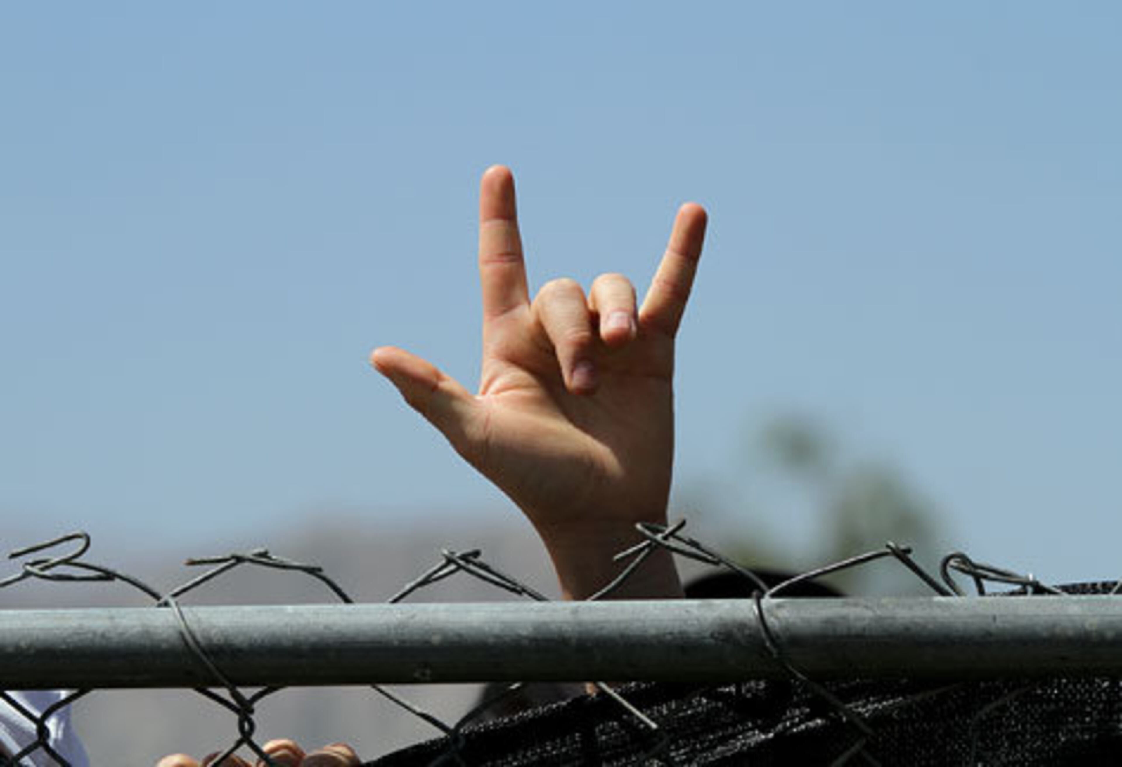 A camper waits behind a locked gate for the opening of the 12th Coachella Valley Music and Arts Festival, Friday, April 15, 2011, in Indio, Calif.