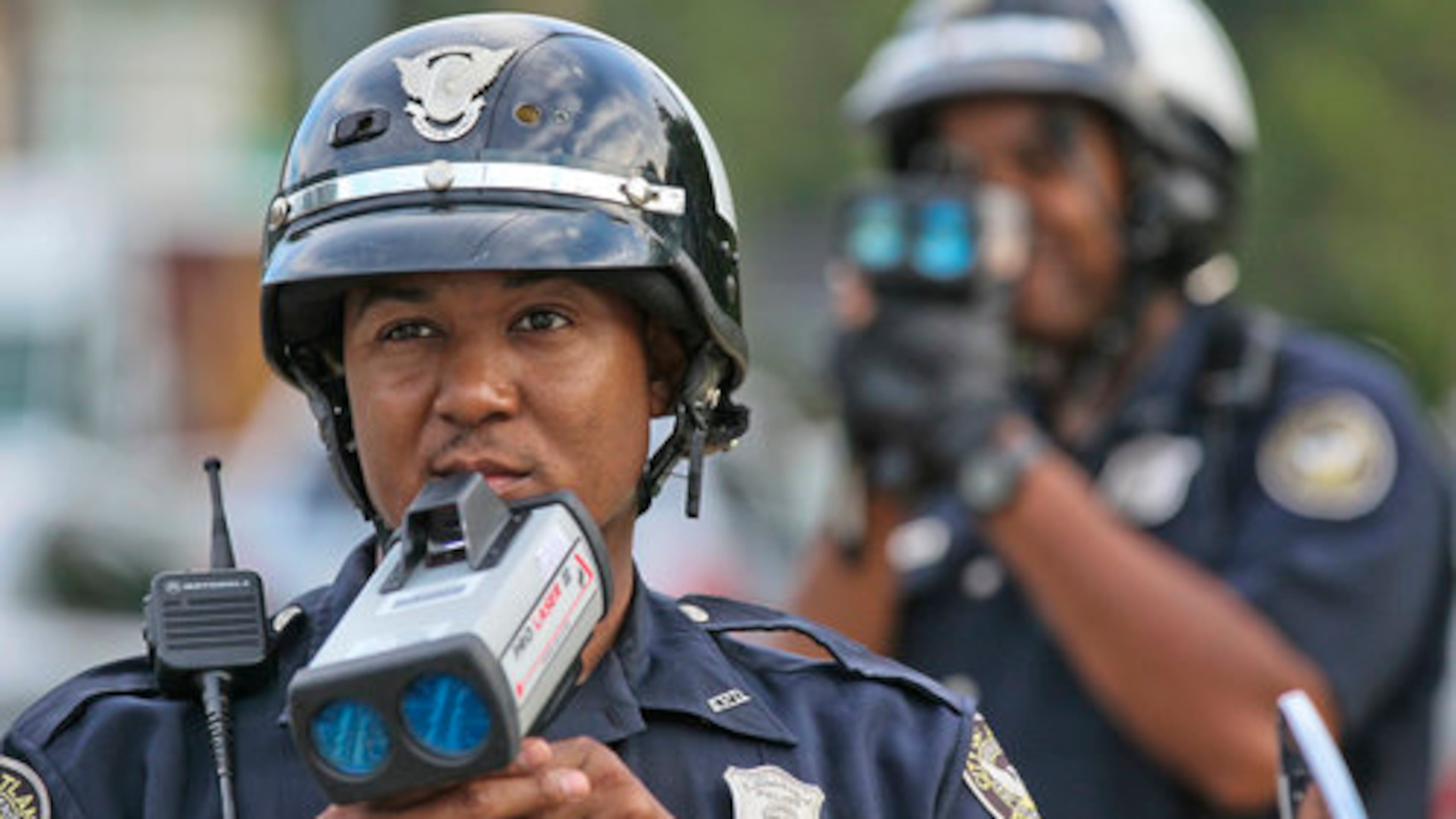 Officers T. Chambliss and D. Brown wait for speeders with their laser guns on Hope Street and Metropolitan Avenue to enter the school zone on Aug. 9, 2012. It's well -established that speeding doesn't really get you to your destination faster. (John Spink/AJC file)