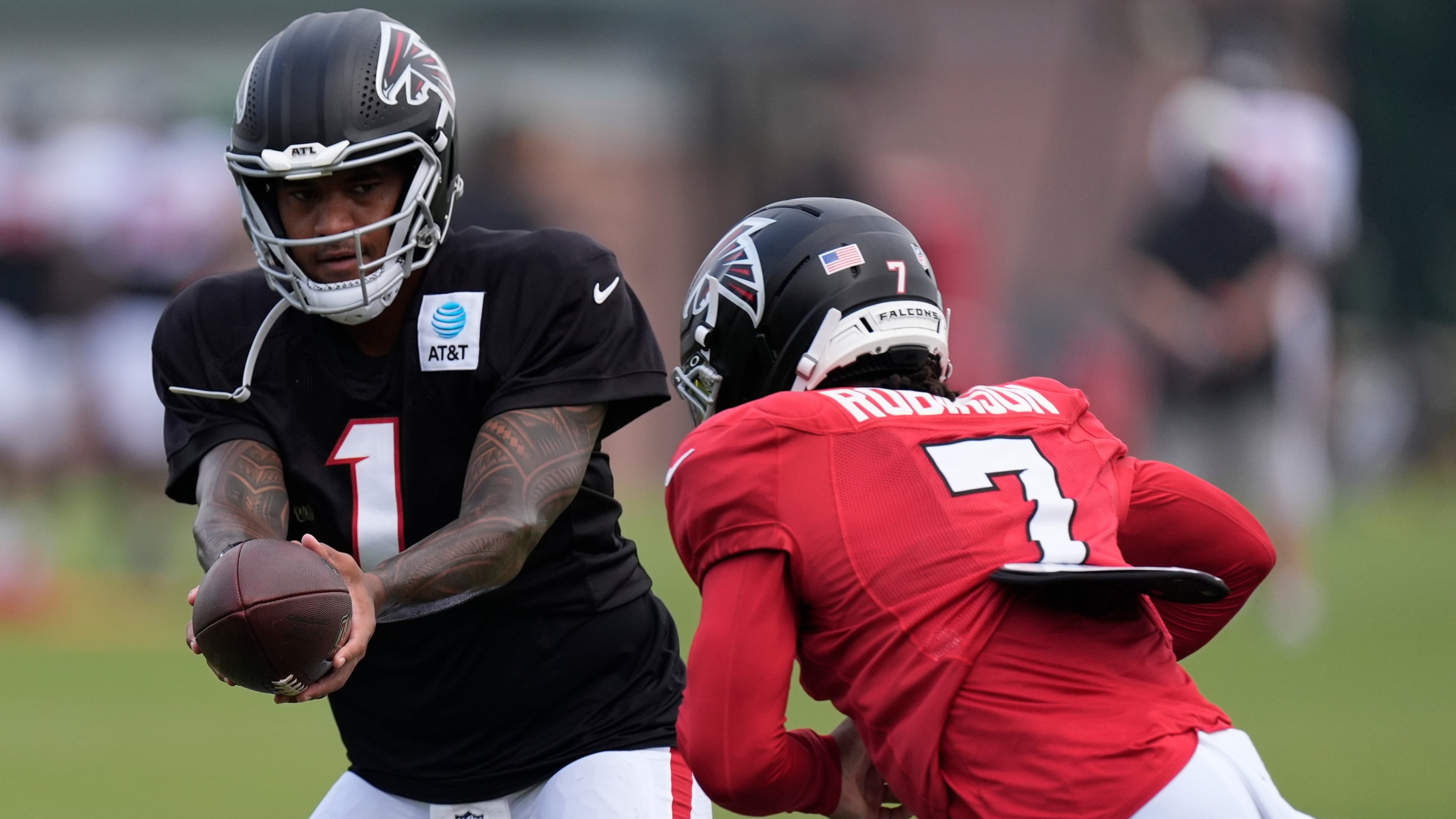 Atlanta Falcons quarterback Tua Tagovailoa hands the ball off to running back Bijan Robinson (7) during an NFL training camp, Friday, Aug. 7, 2026, in Flowery Branch, Ga. (Mike Stewart/AP)