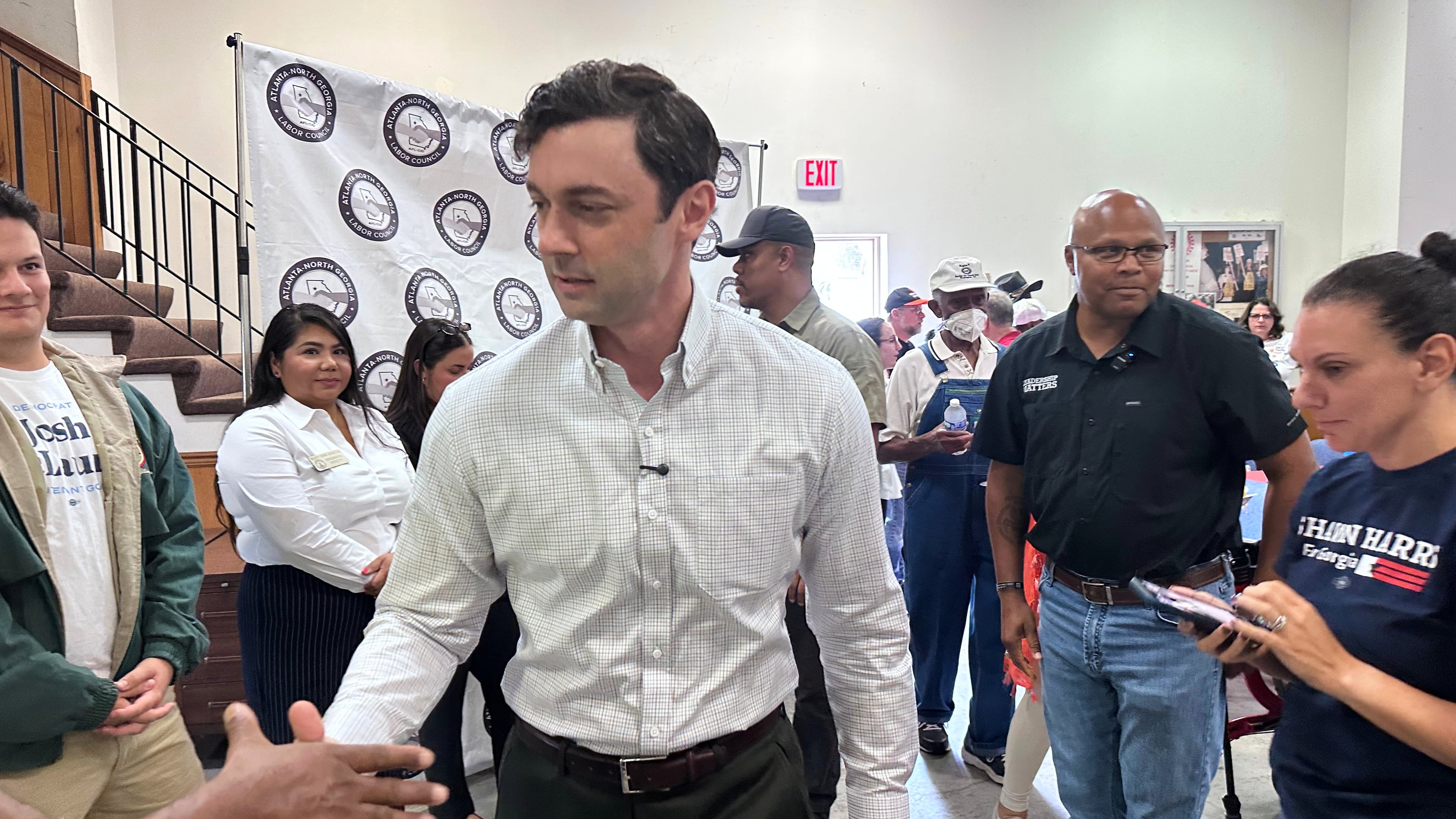 This photo taken with a smartphone shows Sen. Jon Ossoff, D-Ga., greeting union members at an Atlanta-North Georgia Labor Council (AFL-CIO) Labor Day lunch in Hapeville, Ga., Monday, Sept. 7, 2026. (AP Photo/Bill Barrow)