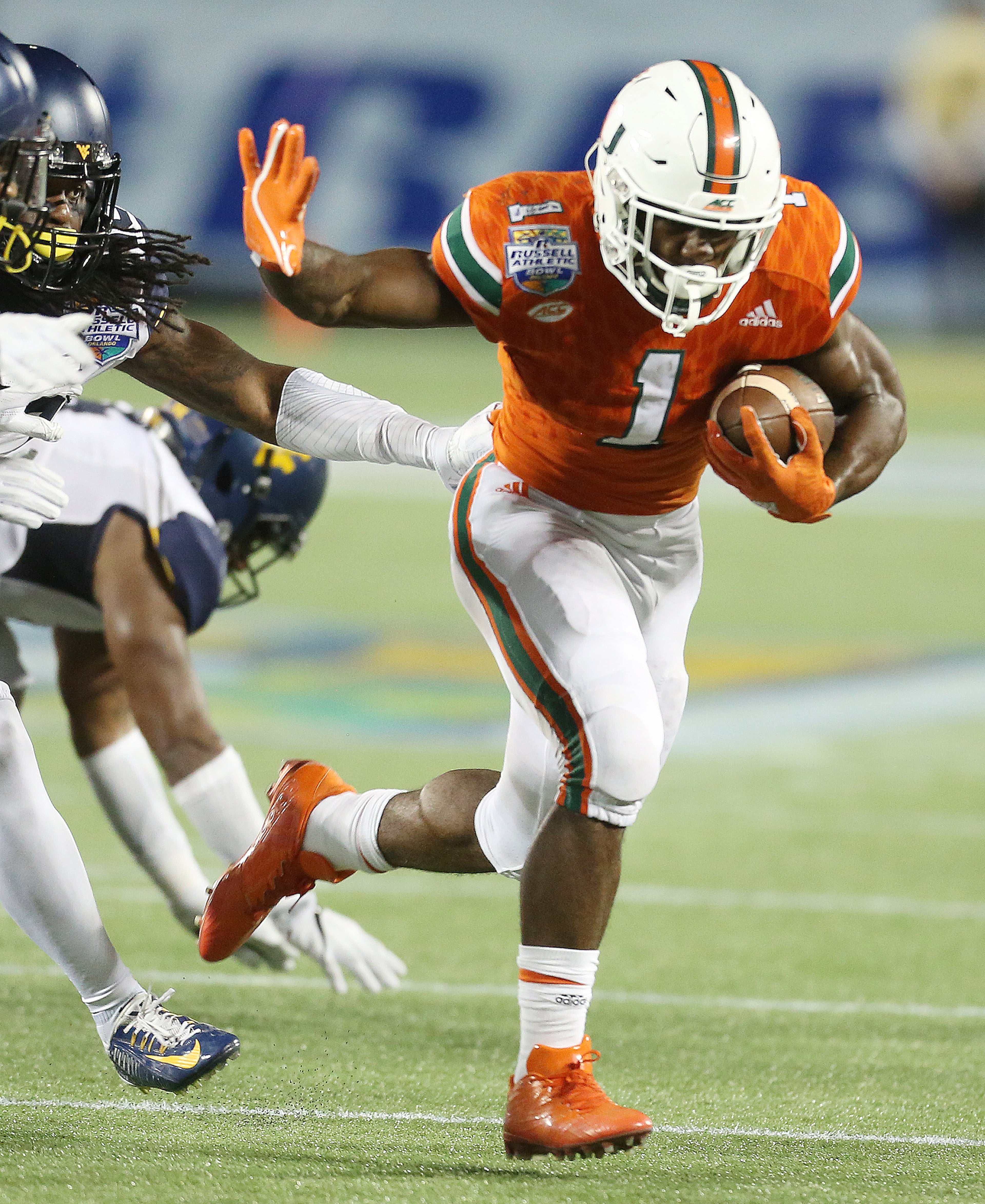 Miami running back Mark Walton (1) carries the ball against West Virginia during the Russell Athletic Bowl at Camping World Stadium in Orlando, Fla., on Wednesday, Dec. 28, 2016. Miami won, 31-14. (Stephen M. Dowell/Orlando Sentinel/TNS)