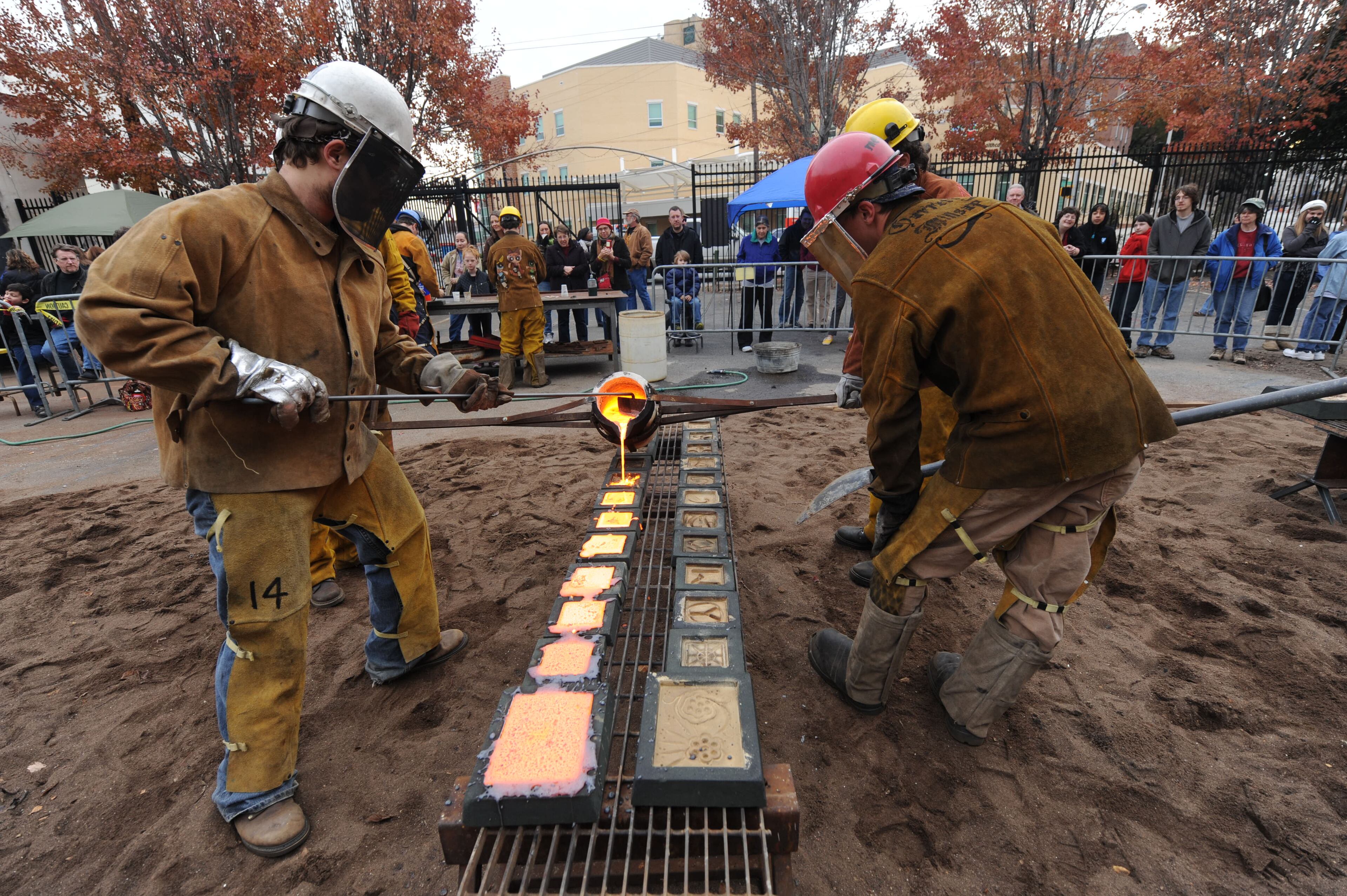 Workers pour iron in scratch molds.