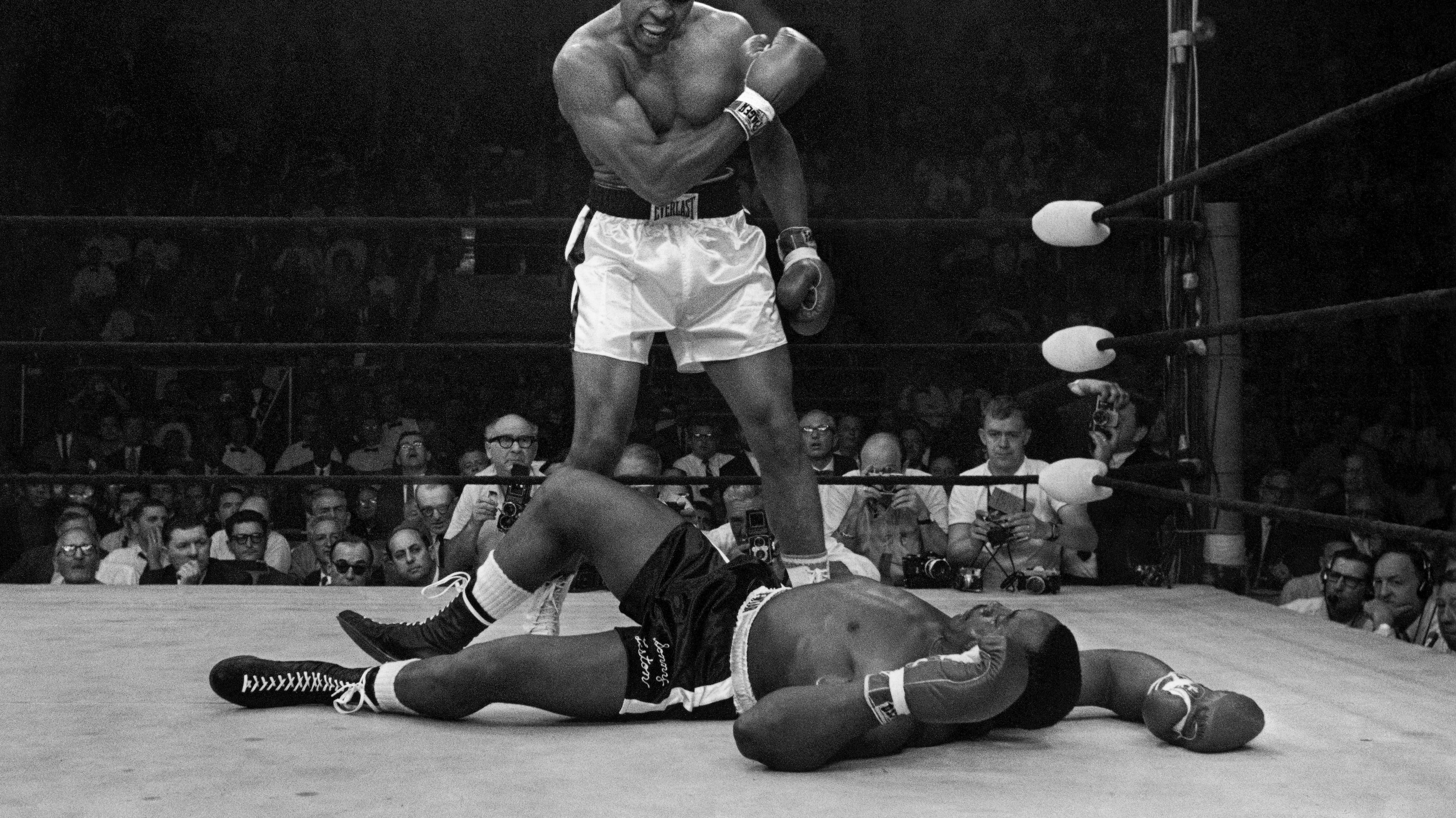 FILE - Heavyweight champion Muhammad Ali stands over fallen challenger Sonny Liston, shouting and gesturing shortly after dropping Liston with a short hard right to the jaw on May 25, 1965, in Lewiston, Maine. (AP Photo/John Rooney, file)