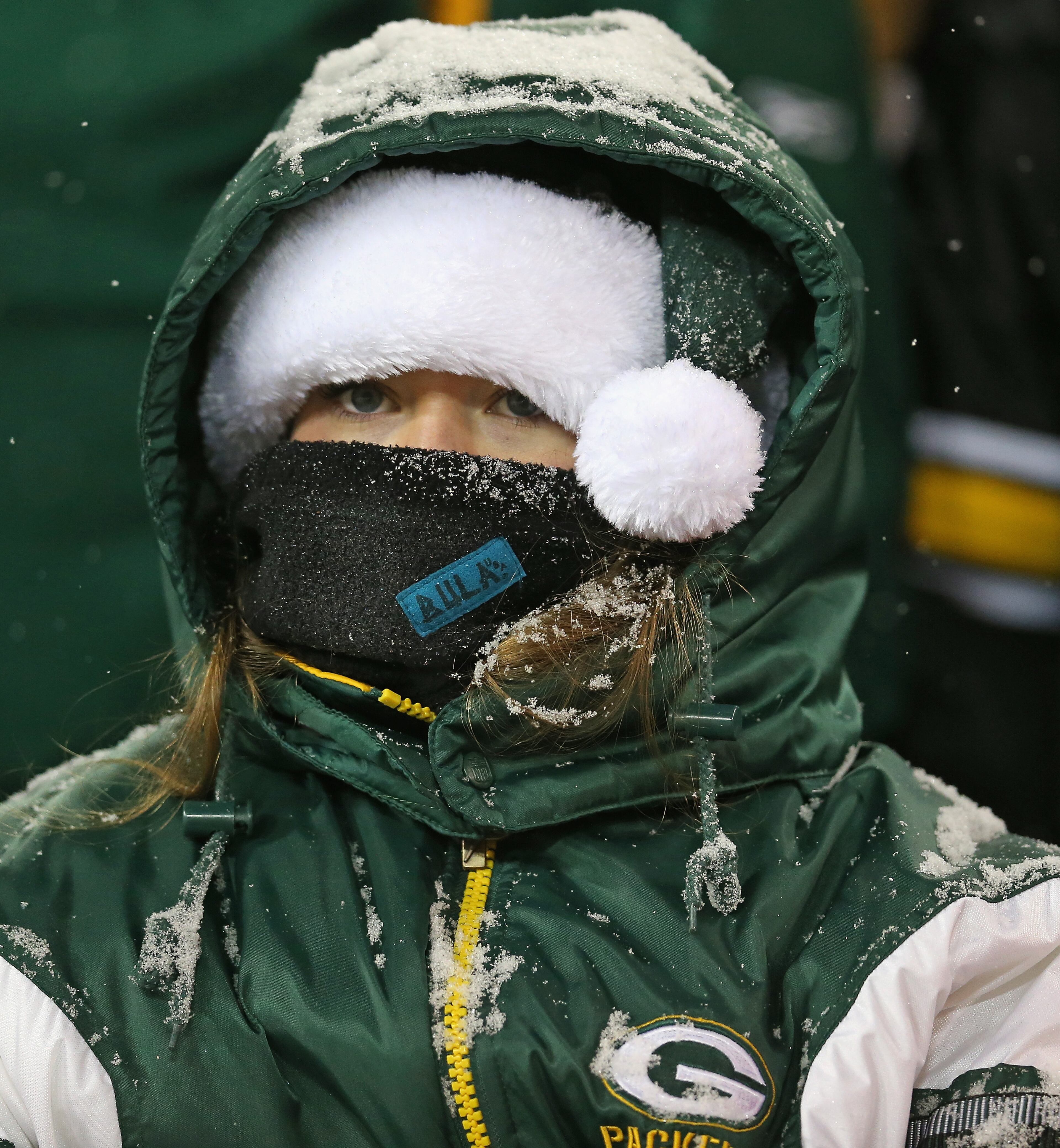 A fan of the Green Bay Packers tries to stay warm during a game between the Packers and the Pittsburgh Steelers at Lambeau Field on Dec. 22, 2013. in Green Bay, Wisc. The Steelers defeated the Packers 38-31. (Photo by Jonathan Daniel/Getty Images)