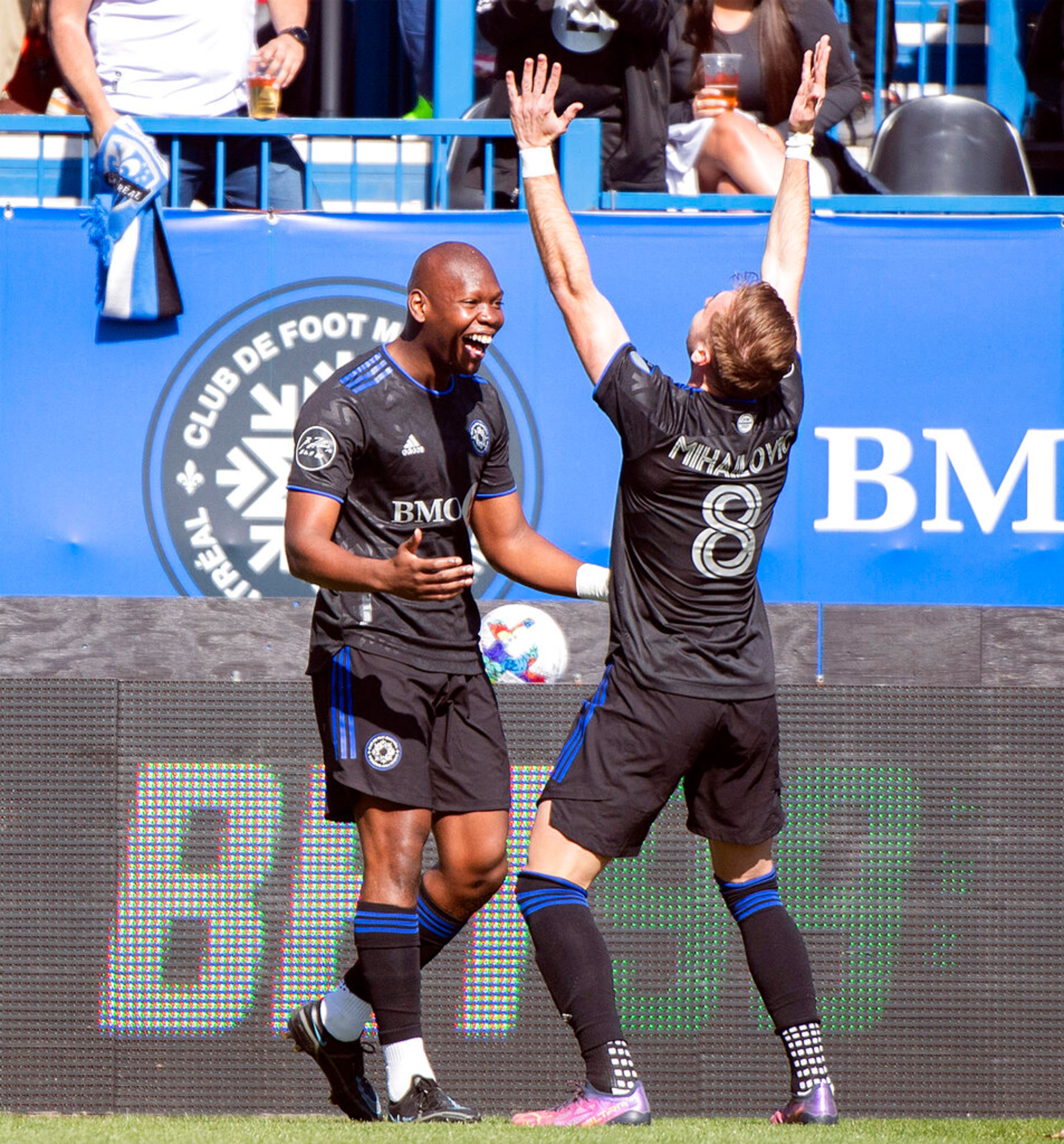 CF Montreal's Kamal Miller, left, celebrates with teammate Djordje Mihailovic after scoring against Atlanta United during the first half of a MLS soccer game in Montreal, Saturday, April 30, 2022. (Graham Hughes/The Canadian Press via AP)