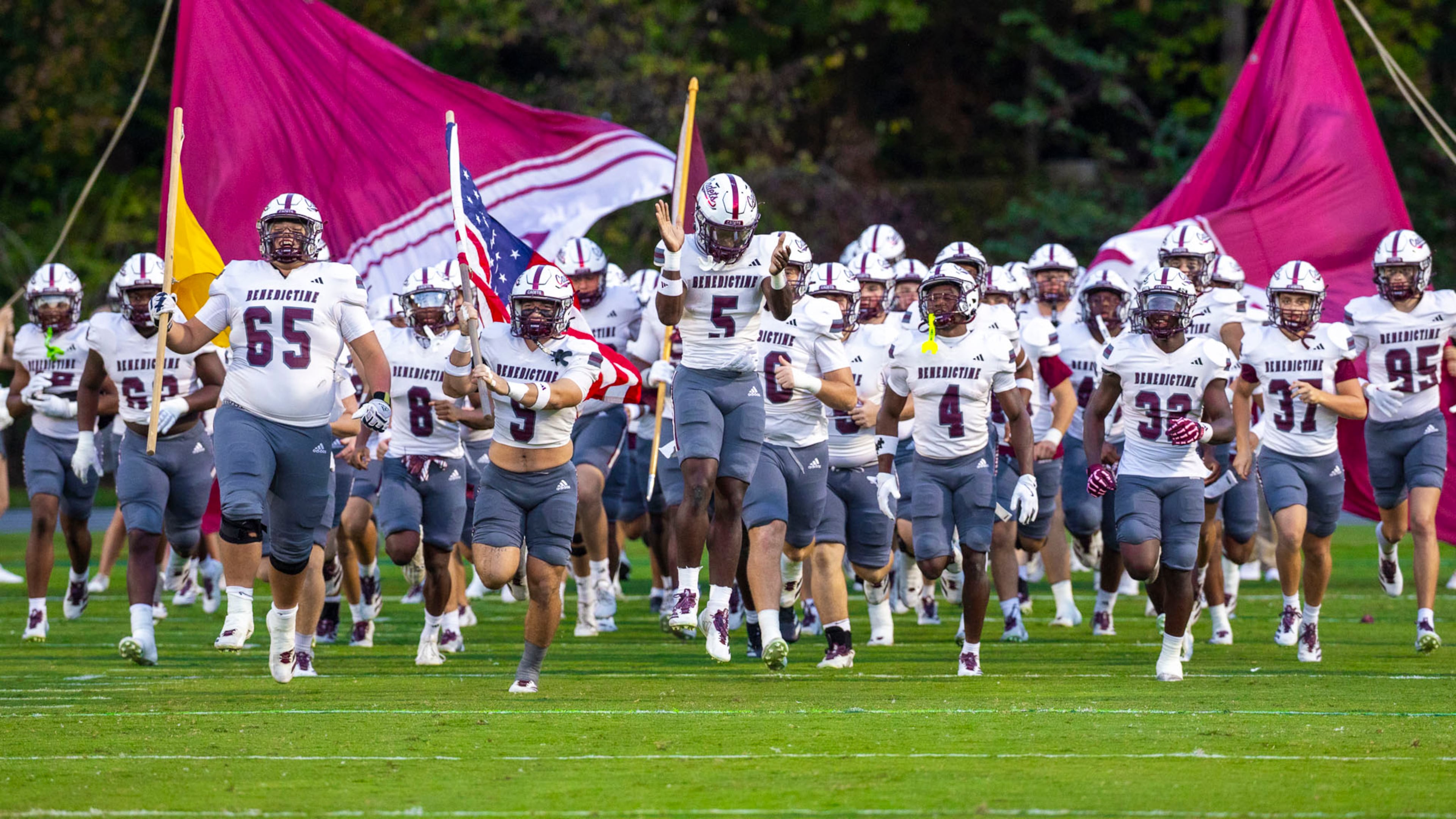 Benedictine players run through the banner before their game against Westminster at Fritz Orr Field on Friday, Sept. 19, 2025, in Atlanta. Benedictine faces Ware County on Friday at Memorial Stadium in Waycross. (Oscar Guevara Saenz for the AJC)