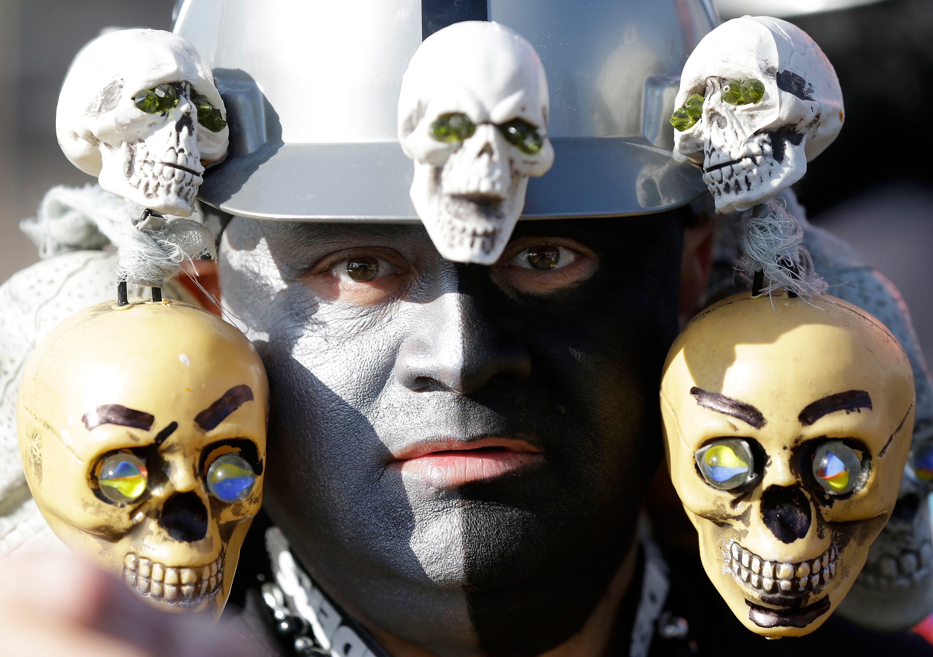 Oakland Raiders fan Douglas Guillen poses for photographs in the O.co Coliseum parking lot before an NFL football game between the Oakland Raiders and the Kansas City Chiefs in Oakland, Calif., Sunday, Dec. 15, 2013. (AP Photo/Marcio Jose Sanchez)