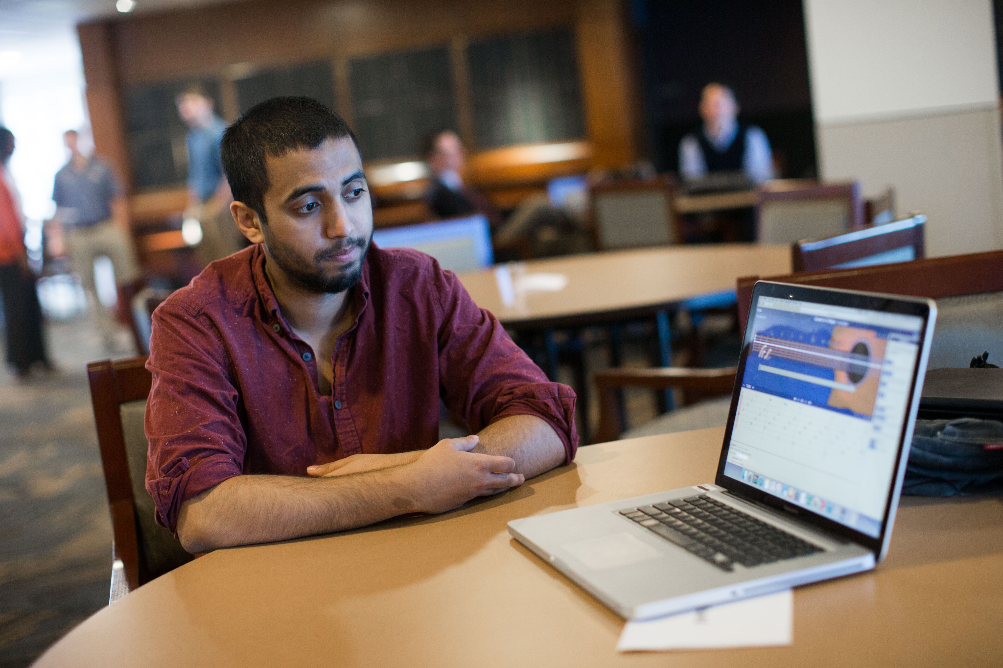 Ali Abid, poses with FretWizard, a computer application he created along with Molly Ricks, not pictured, that helps students learn to play the guitar. BRANDEN CAMP/SPECIAL
