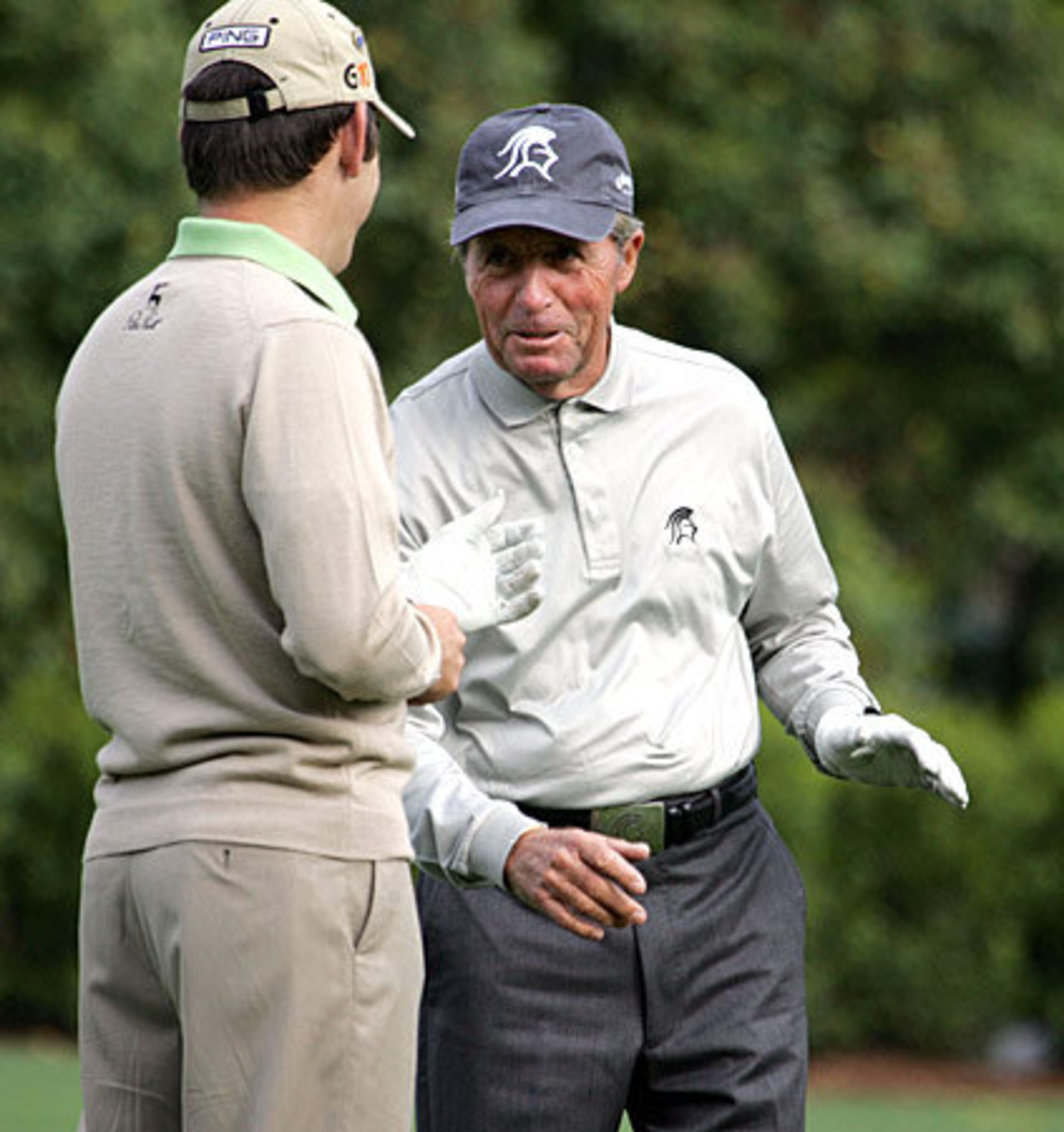 Three-time Masters champ Gary Player (right) chats with Louis Oosthuizen on the driving range early Monday. Player donned the famed green jacket in 1961, 1974 and 1978.