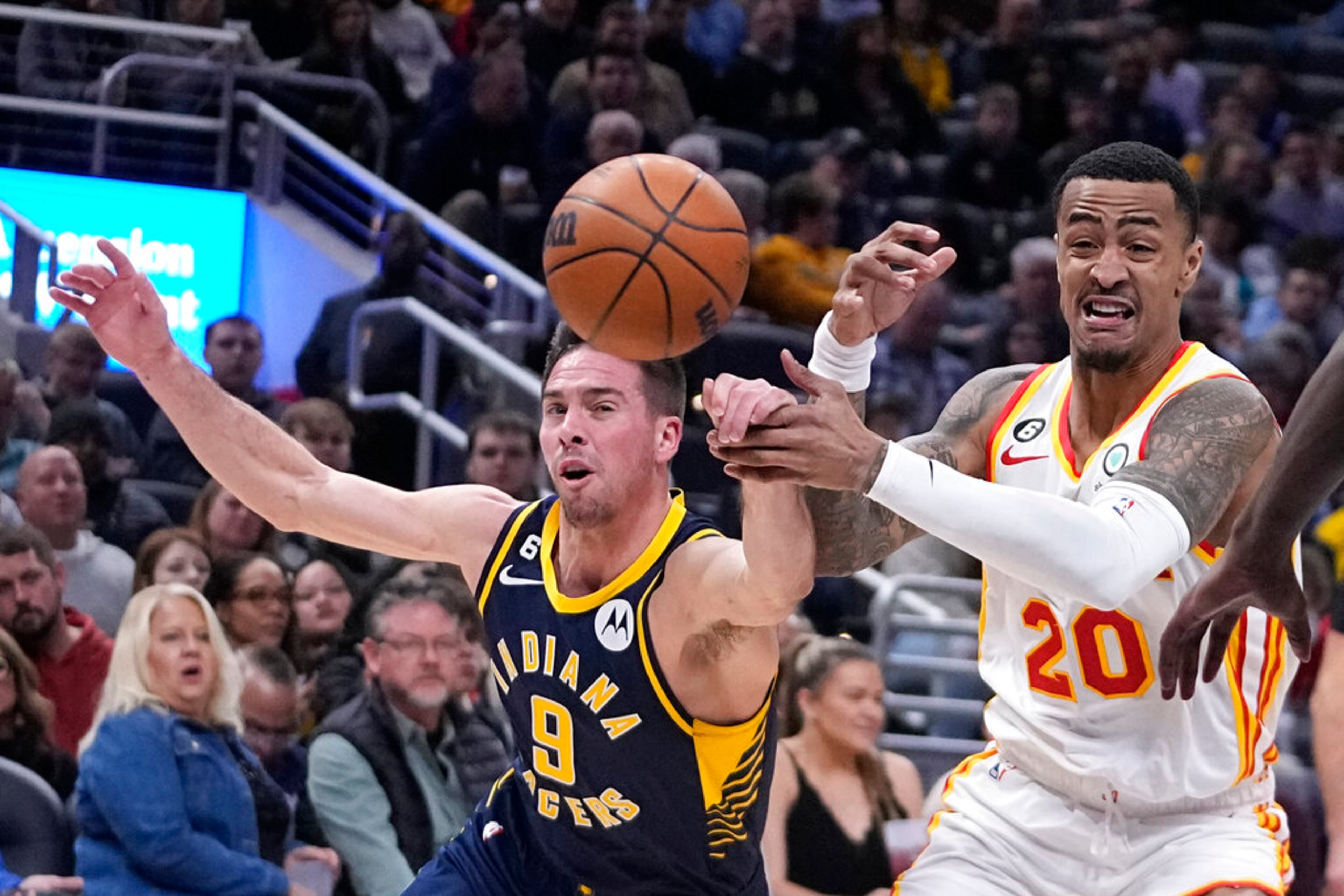Indiana Pacers' T.J. McConnell (9) knocks the ball away from Atlanta Hawks' John Collins (20) during the first half of an NBA basketball game Tuesday, Dec. 27, 2022, in Indianapolis. (AP Photo/Darron Cummings)