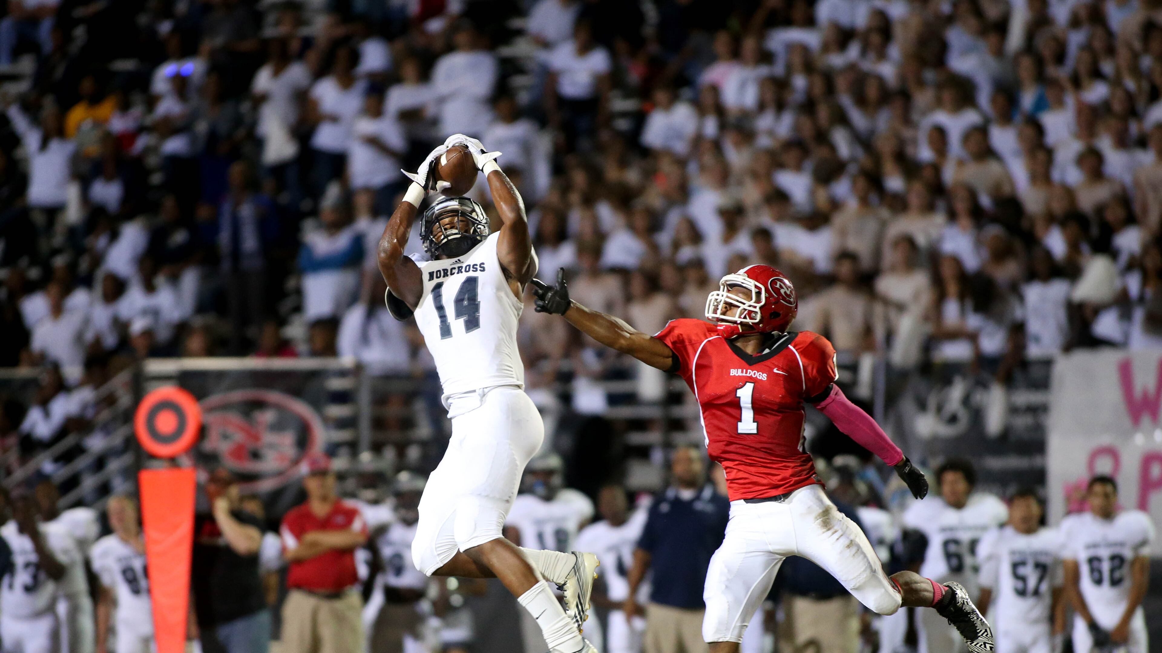 On third and 46, Norcross wide receiver Jared Pinkney (14) catches a pass in front of North Gwinnett defensive back Jaye Stackhouse (1) for an 86-yard touchdown in the first half of their game Friday in Suwanee, Ga., October 3, 2014. JASON GETZ / SPECIAL