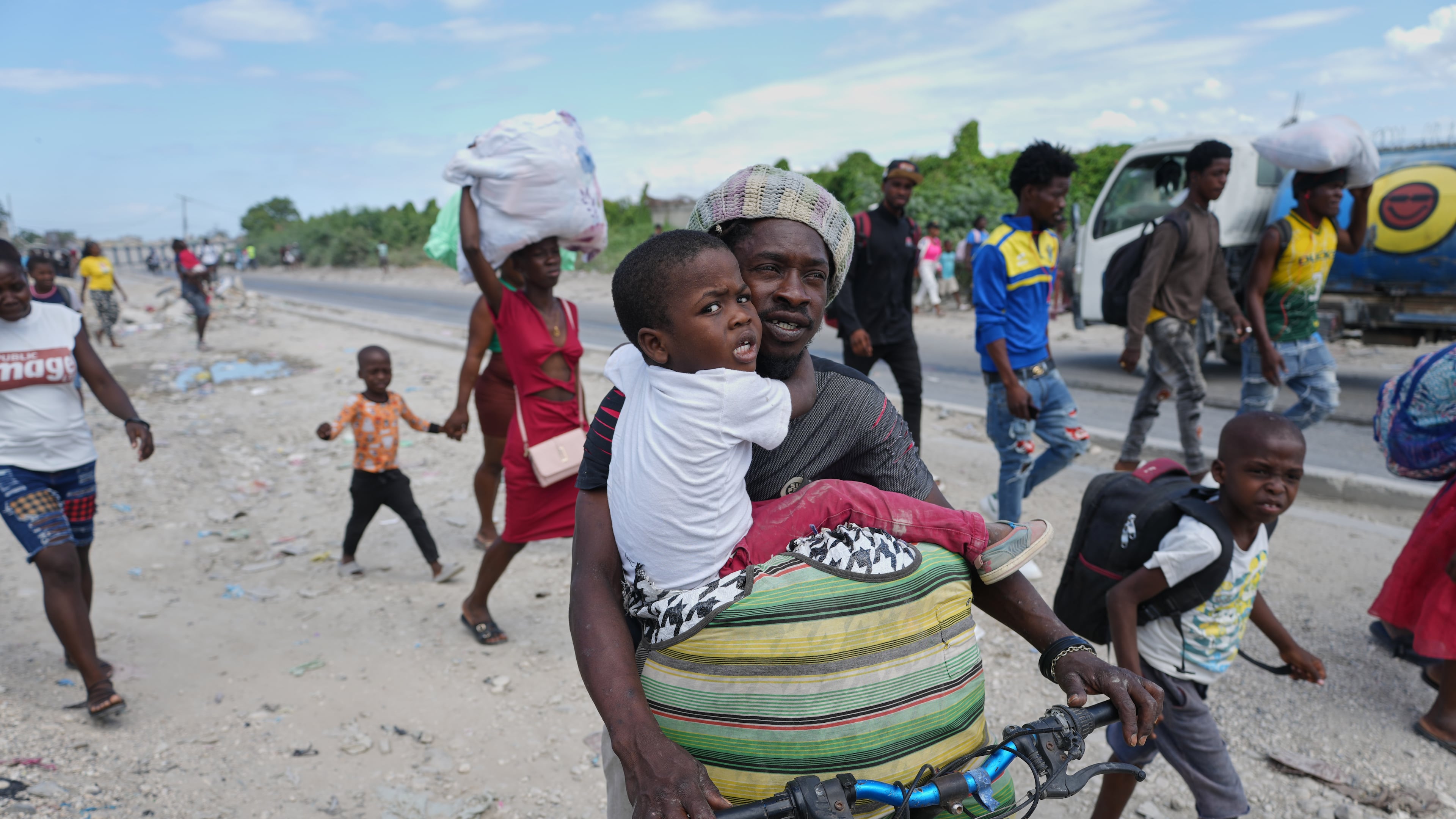 Residents flee their homes to escape clashes between armed gangs in Port-au-Prince, Haiti, Monday, May 11, 2026. (AP Photo/Odelyn Joseph)