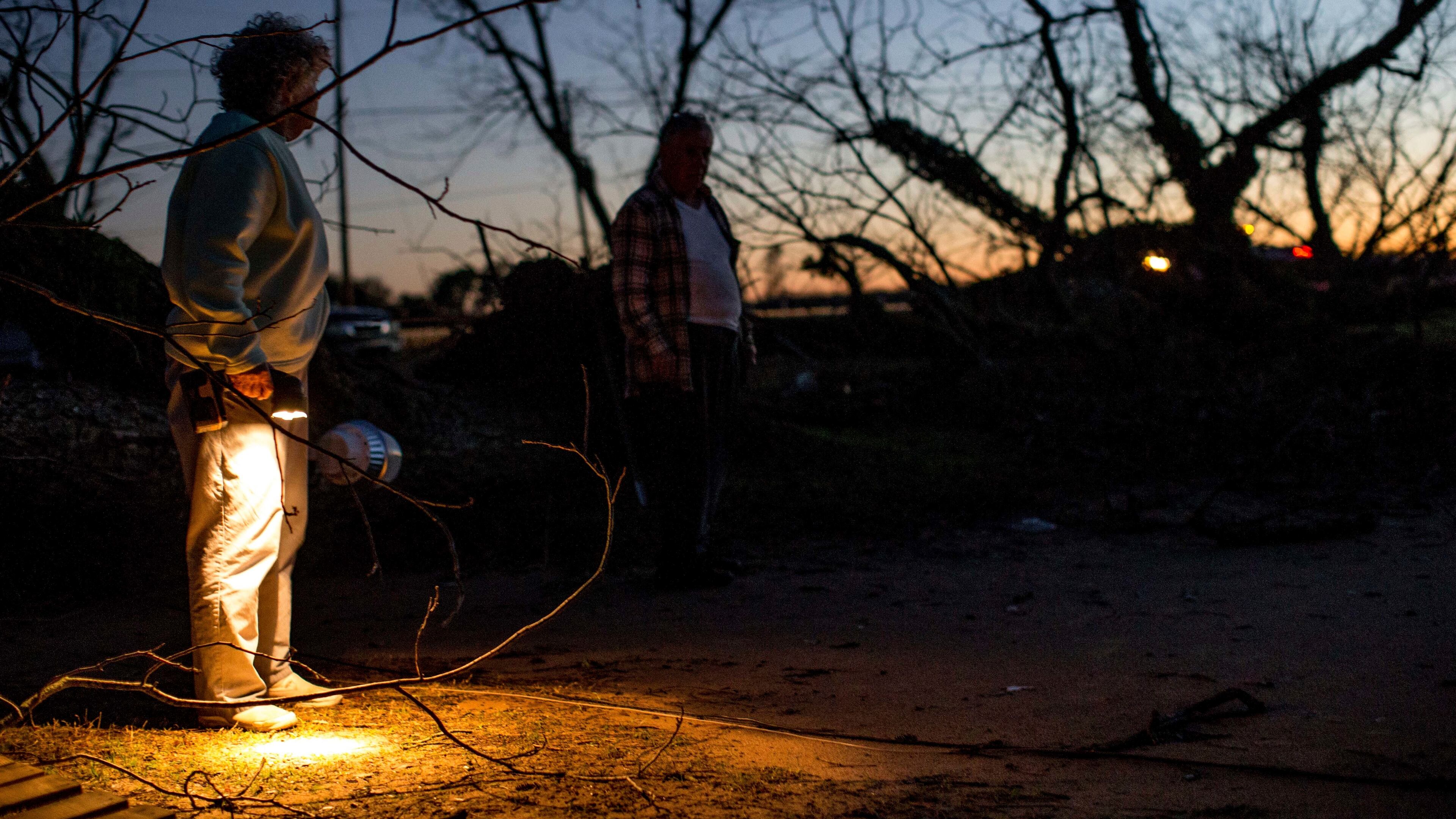Sandra and her husband Ken stand near a tree that fell outside their home after a severe storm, Sunday, Jan. 22, 2017, in Albany, Ga. Nathan Deal declared a state of emergency in several counties, including Cook, that have suffered deaths, injuries and severe damage from weekend storms. (AP Photo/Branden Camp)